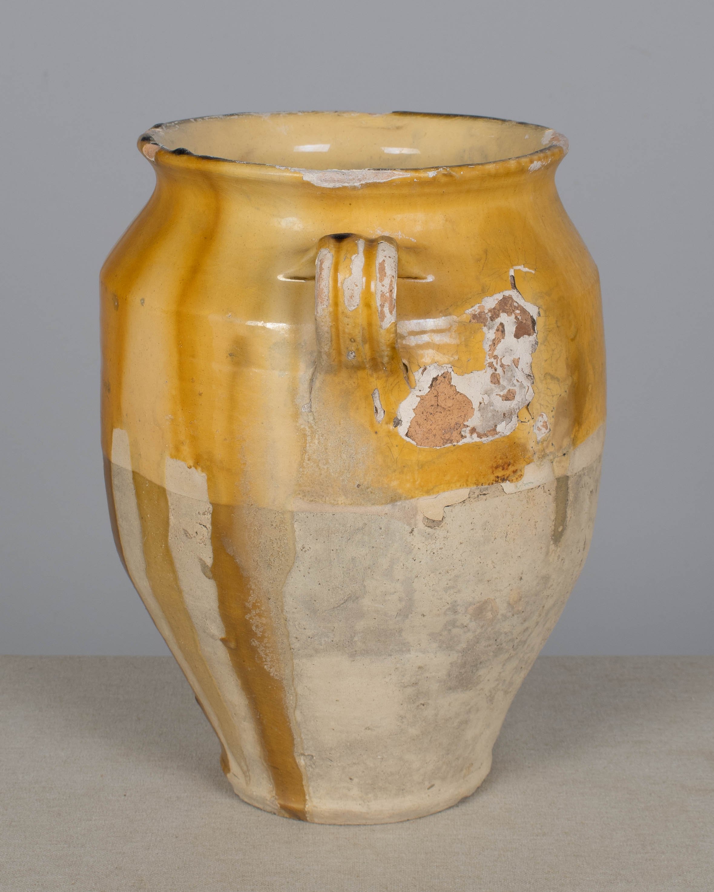 An earthenware confit pot from the Southwest of France with traditional yellow ochre drip glaze.