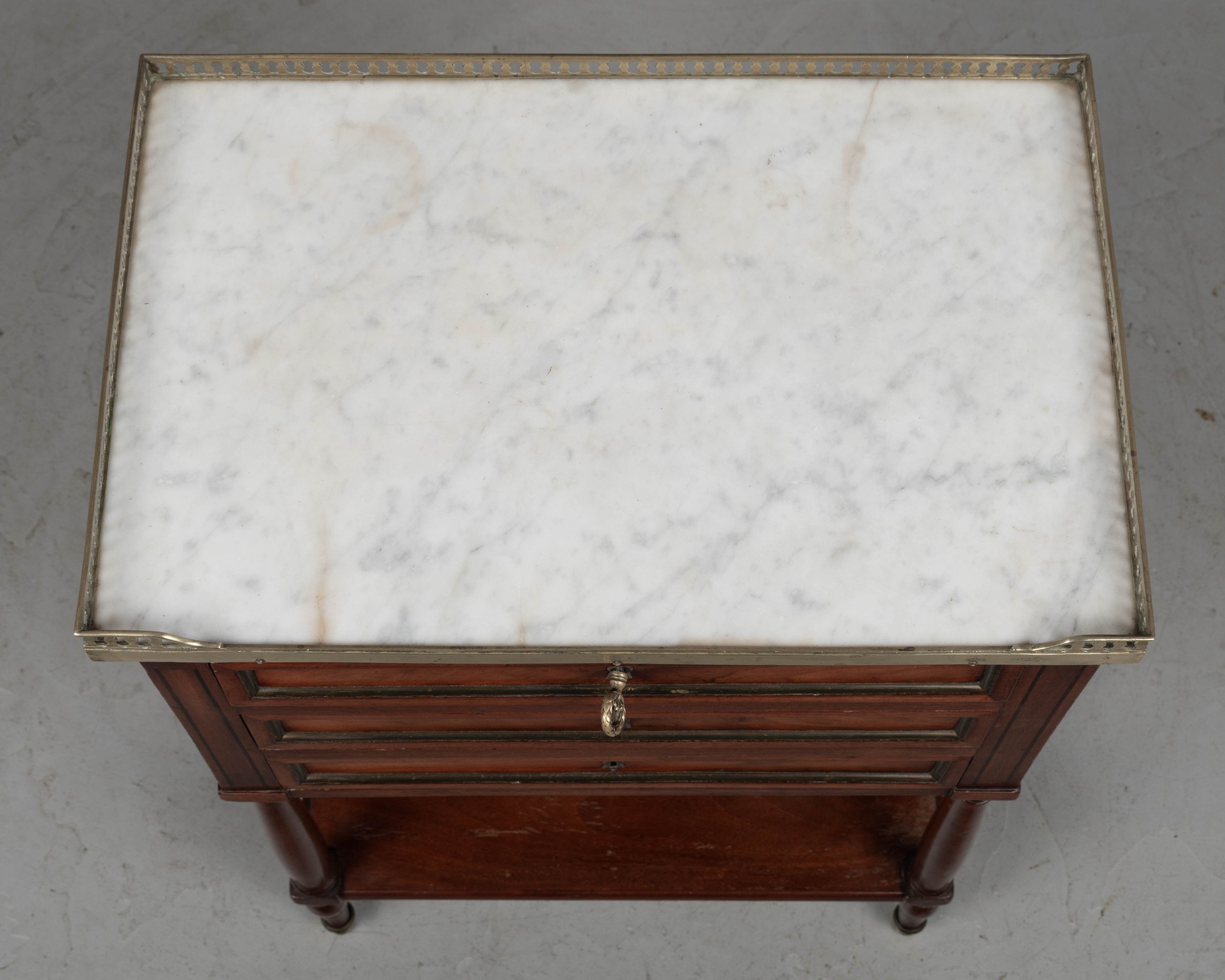 A 19th century French Louis XVI style marble top nightstand, or side table, made of veneers of mahogany with solid oak as a secondary wood