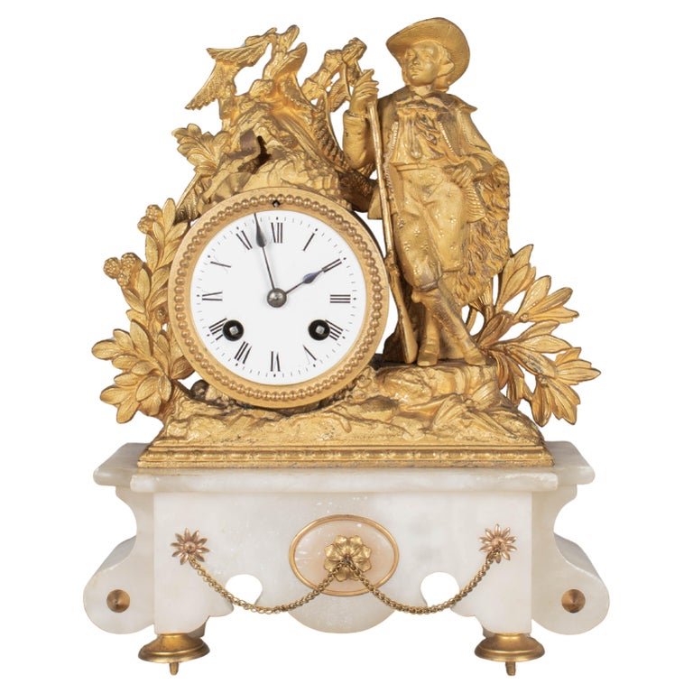 A 19th century Napoleon III French dor&eacute; bronze mantel clock by Philippe H. Mourey. Fine casting of a braconni&egrave;r, or poacher, leaning casually with his rifle and powder horn in a woodland setting. Bright gilt bronze patina. Carved onyx b