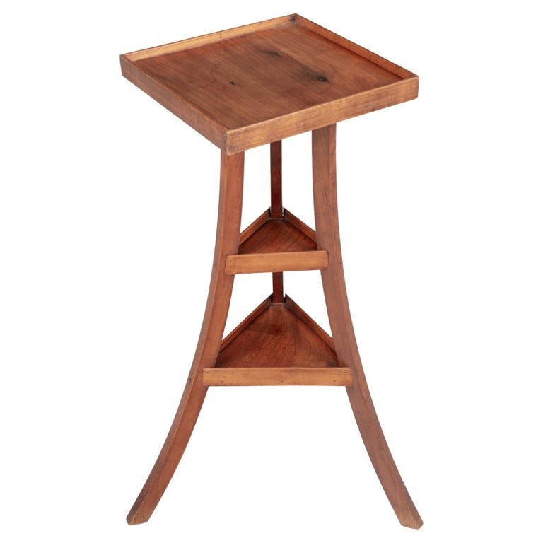 A French Arts &amp; Crafts style small tripod accent table or pedestal, hand-crafted of solid cherry wood. Interesting form with square top and curved legs joined by triangle shelves. Circa 1940s. Shipping: $100
Dimensions: 17.5&quot; x 17.5&quot; x 