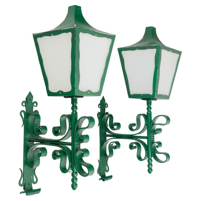 A pair of large scale architectural wall lanterns with decorative wrought iron brackets. Newly painted green with opaque plexiglass panes. Rewired and in working condition. Circa 1950s.
Dimensions: 38&quot;H x 20.5&quot;D x 11.75&quot;W

#81174