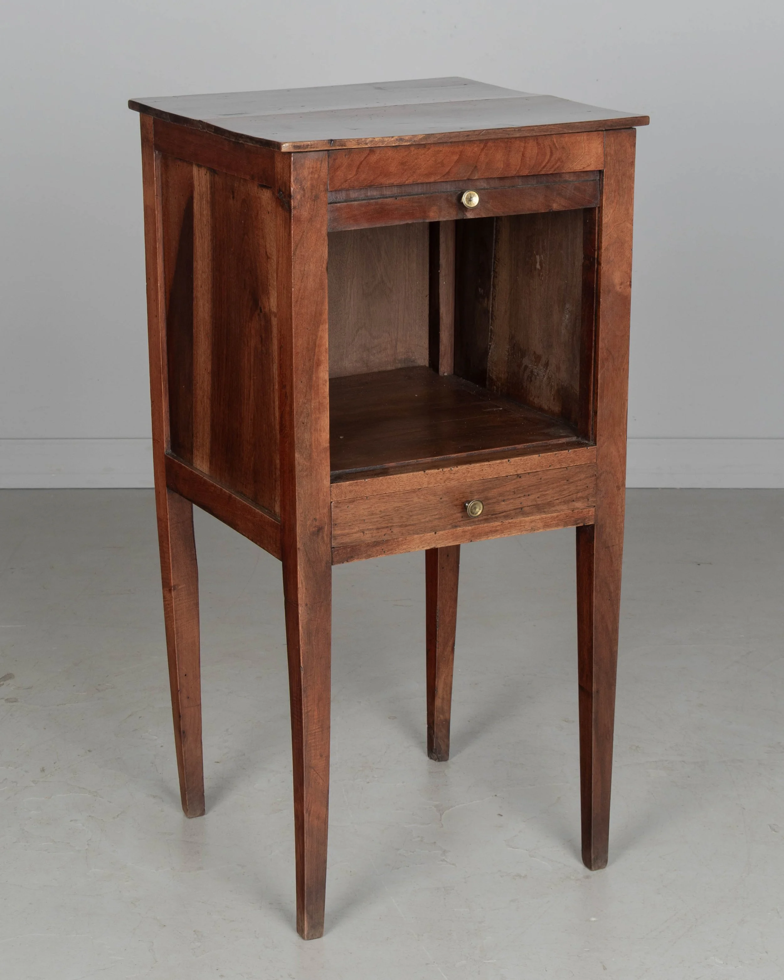 A 19th century French Country walnut side table, or nightstand, with a vertical tambour door above a slim dovetailed drawer