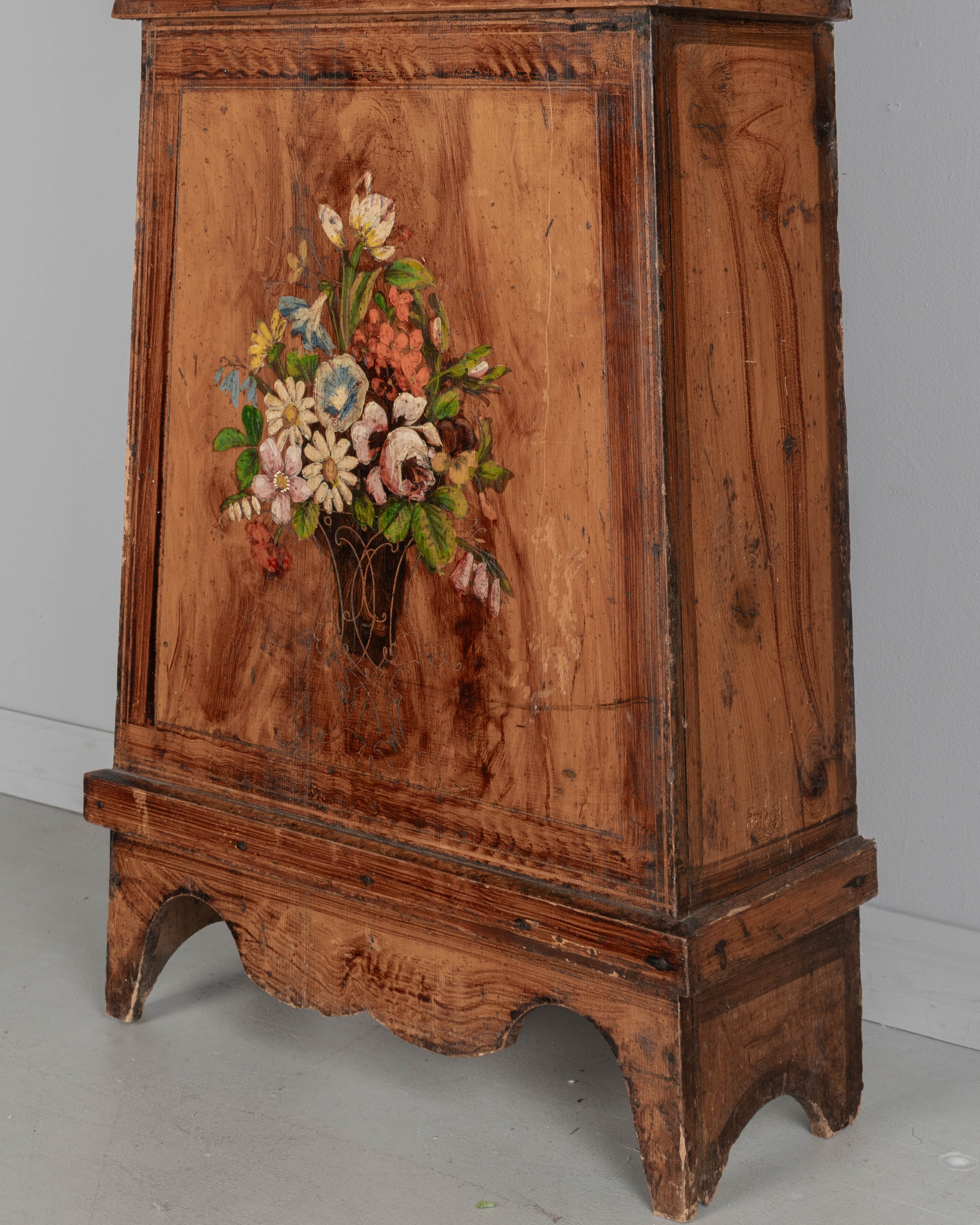 19th century Country French comtoise, or grandfather clock, with polychrome painted pine case and embossed brass pendulum.