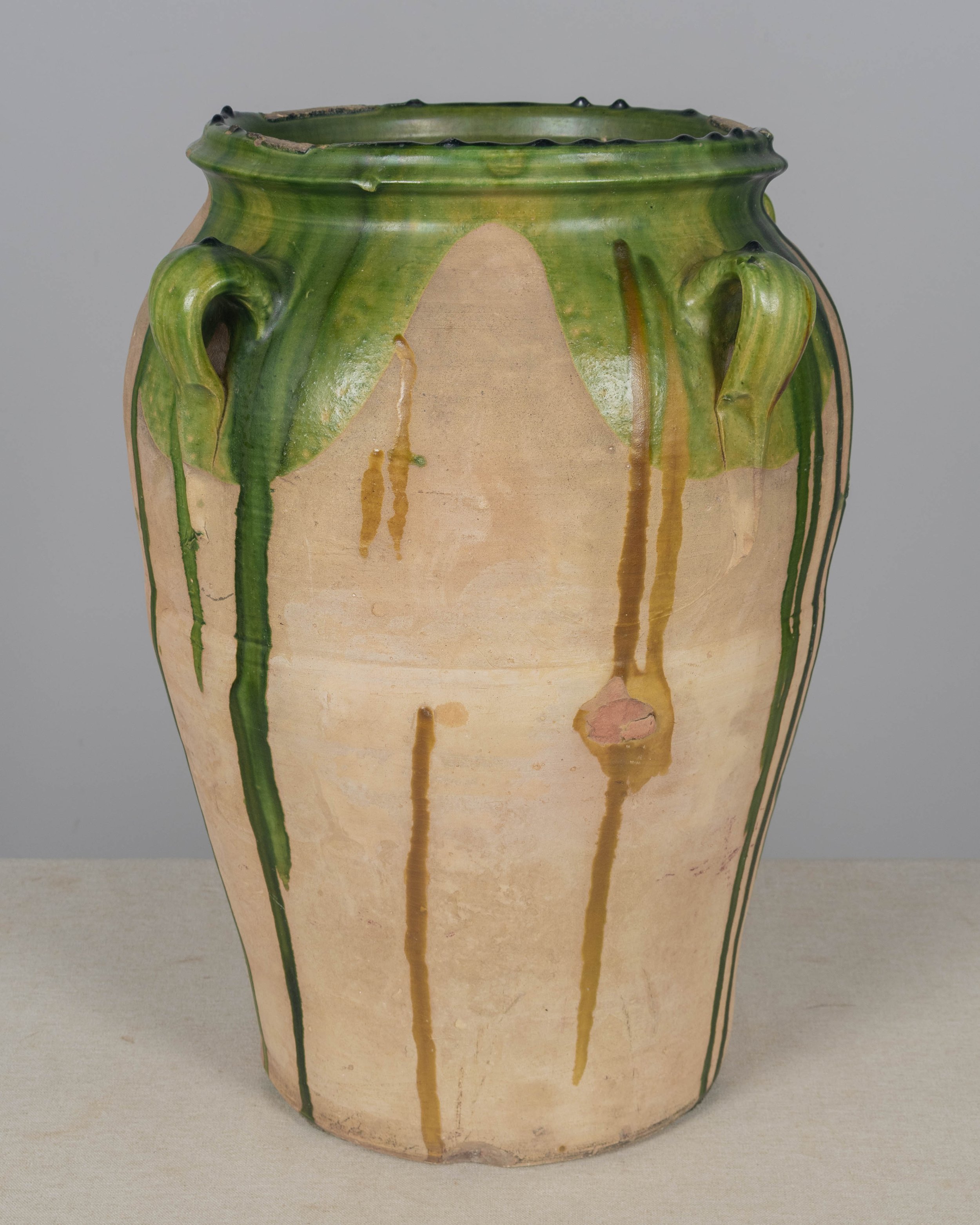 A large 19th-century terracotta olive oil jar with green drip glaze from Southwest France.