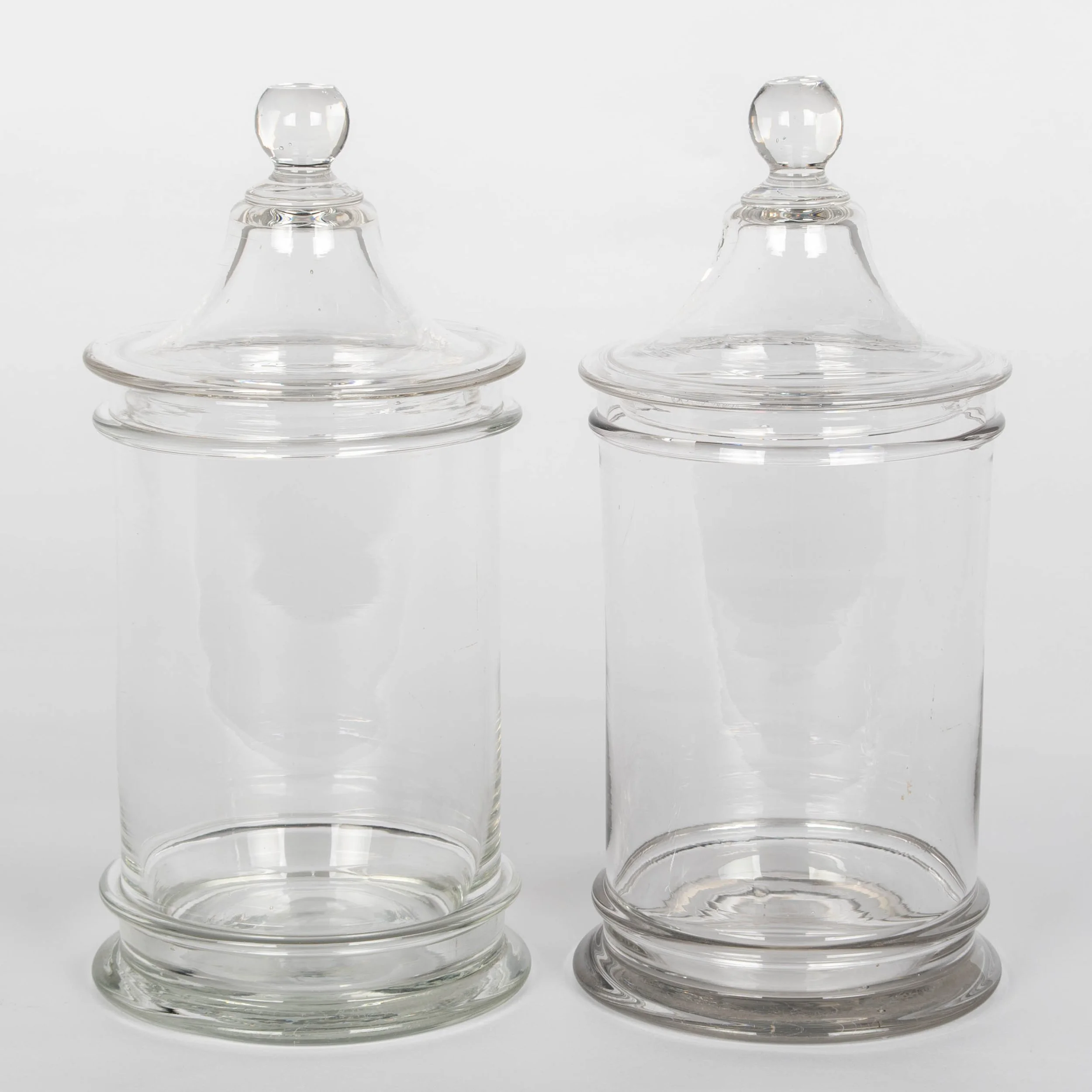 A pair of French hand-blown clear glass lidded apothecary or candy jars