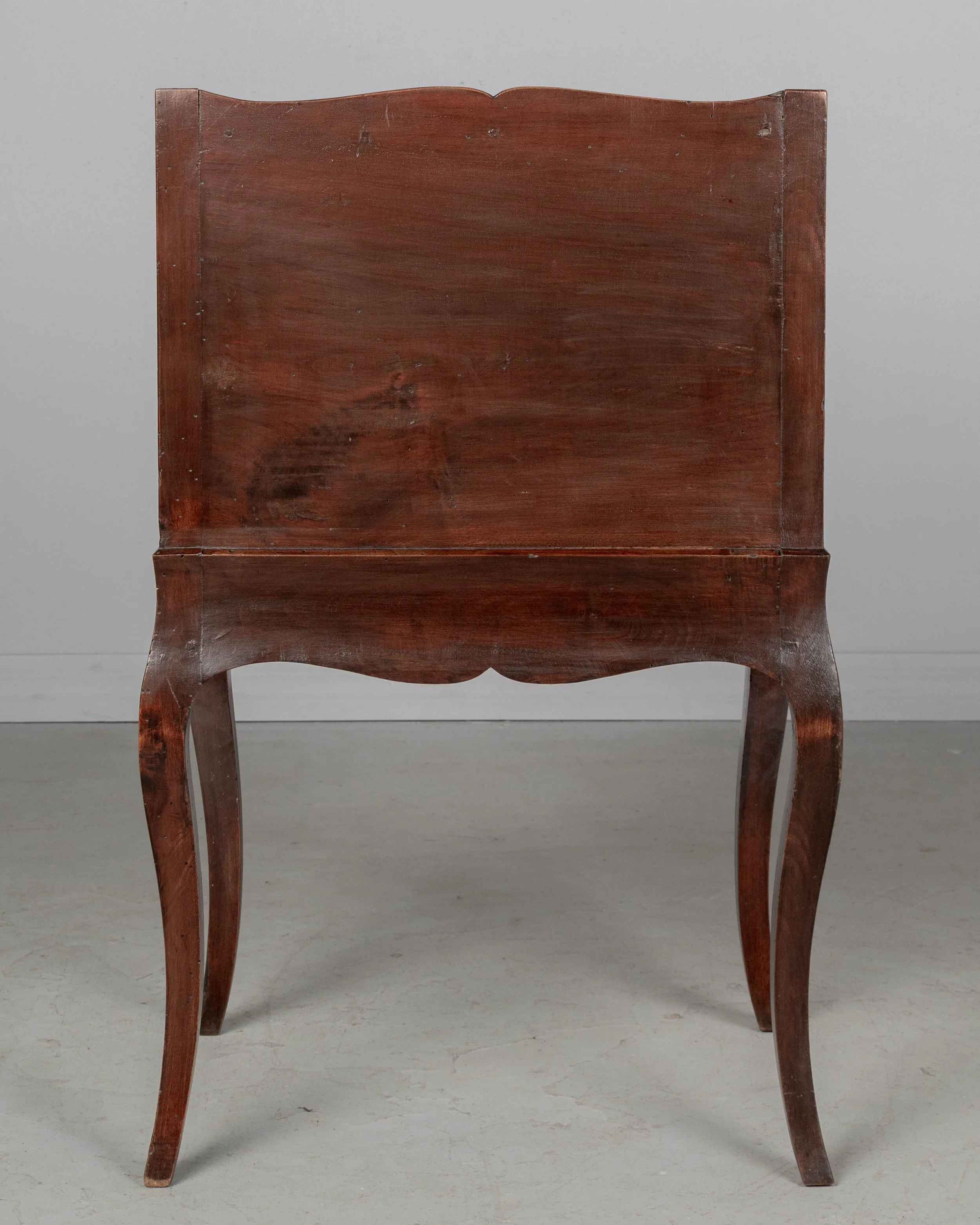 An early 20th century Louis XV Country French side table or nightstand made of solid walnut with an open niche and pierced heart shaped cut-outs on the sides.