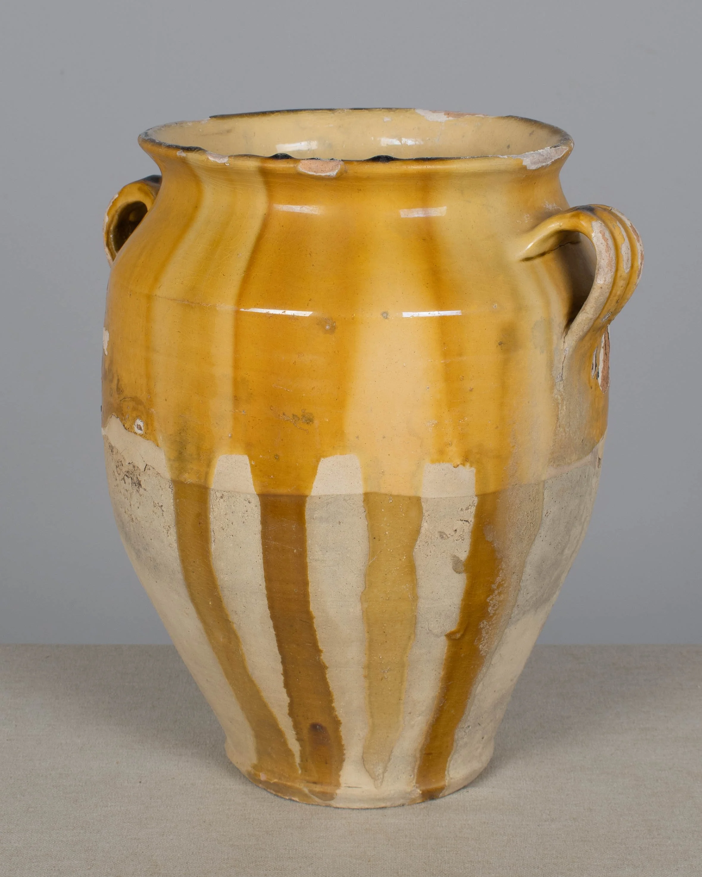 An earthenware confit pot from the Southwest of France with traditional yellow ochre drip glaze.