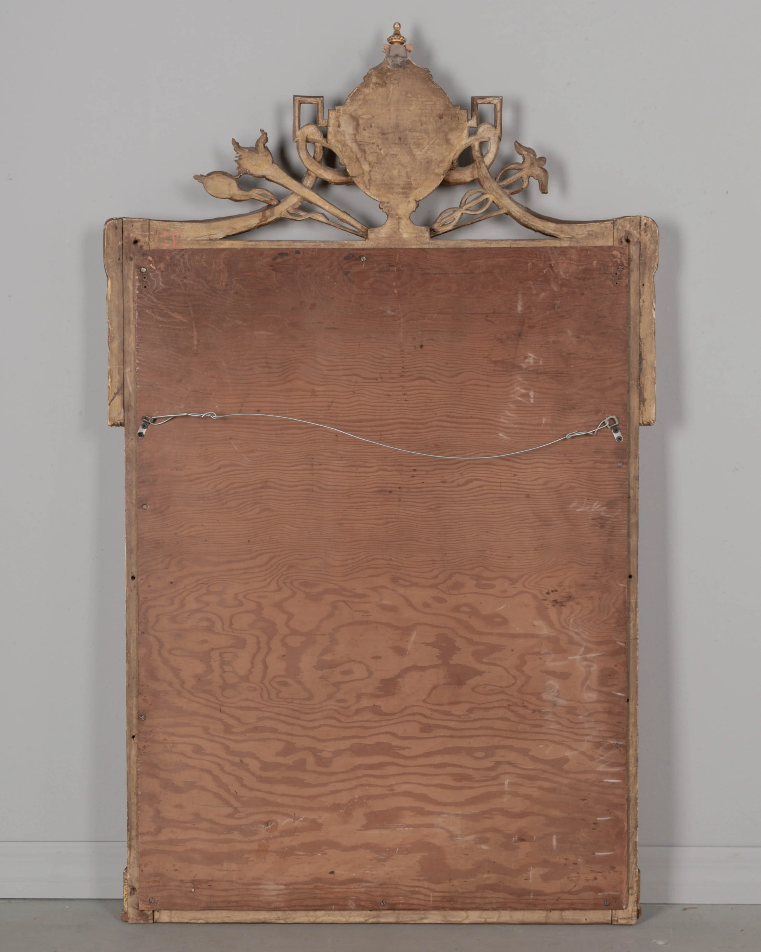 A Louis XVI style French giltwood mirror. Hand carved crest with large urn, torch, ribbons, and garlands.