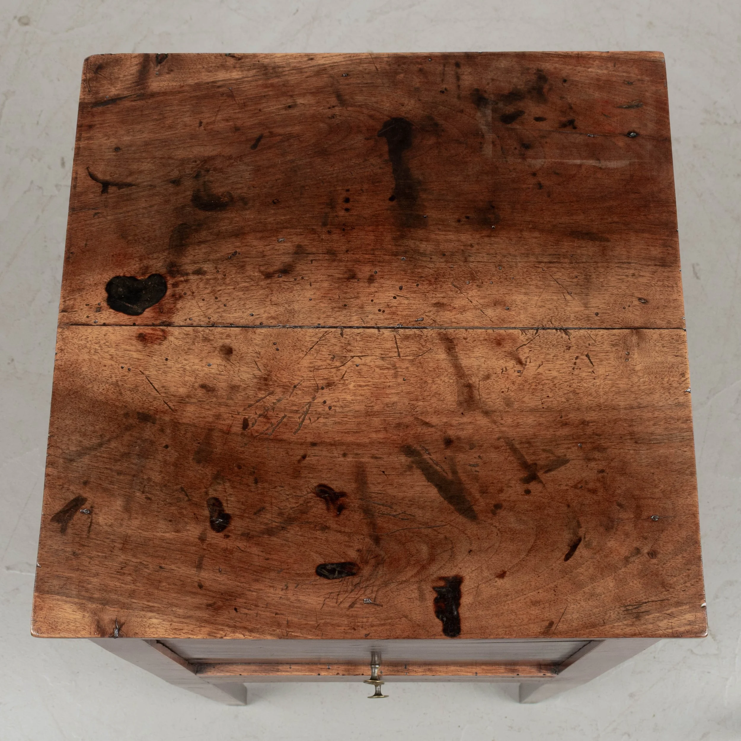 A 19th century French Country walnut side table, or nightstand, with a vertical tambour door above a slim dovetailed drawer