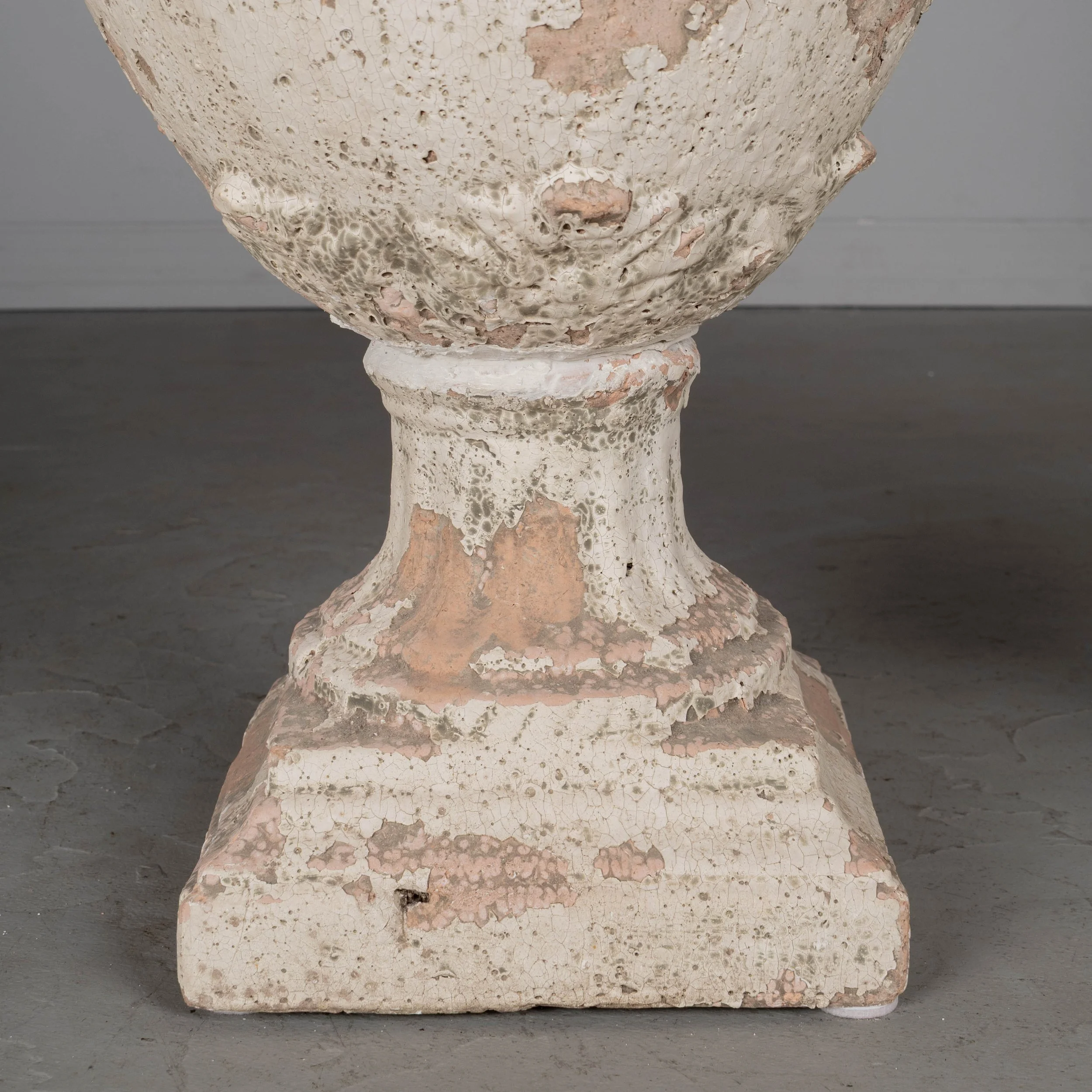 A pair of French terracotta garden urns with lids. Classical vase form on pedestal base, decorated in acanthus leaf motif with large acorn finials on lids.
