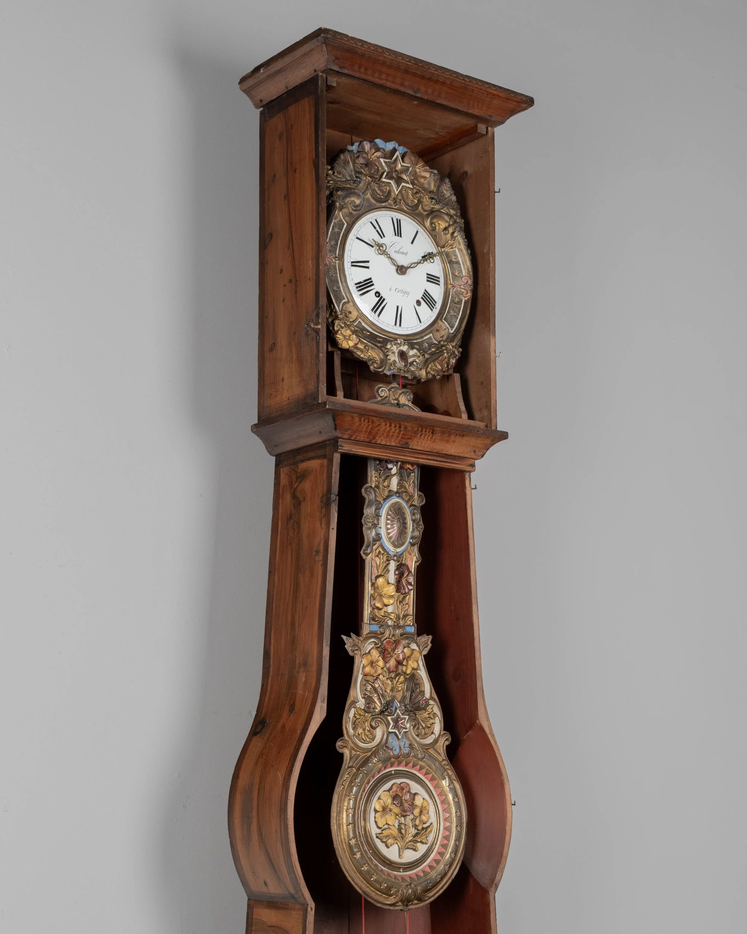 19th century Country French comtoise, or grandfather clock, with polychrome painted pine case and embossed brass pendulum.