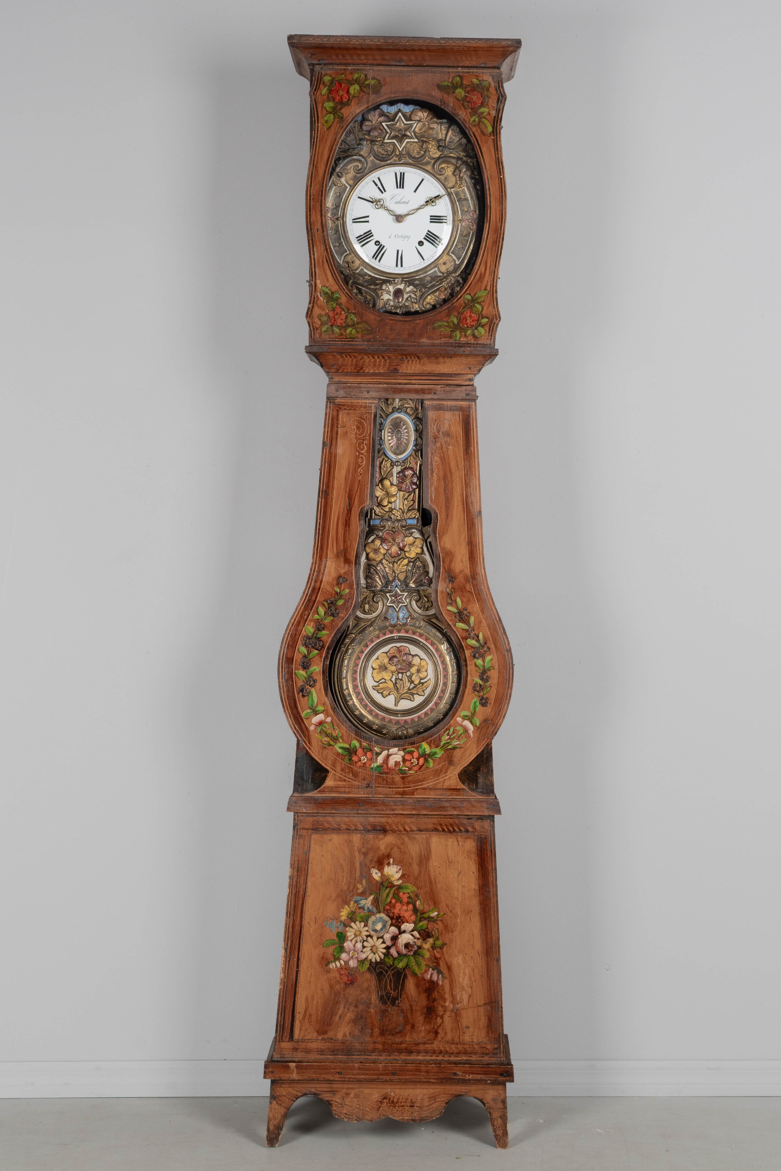 19th century Country French comtoise, or grandfather clock, with polychrome painted pine case and embossed brass pendulum.
