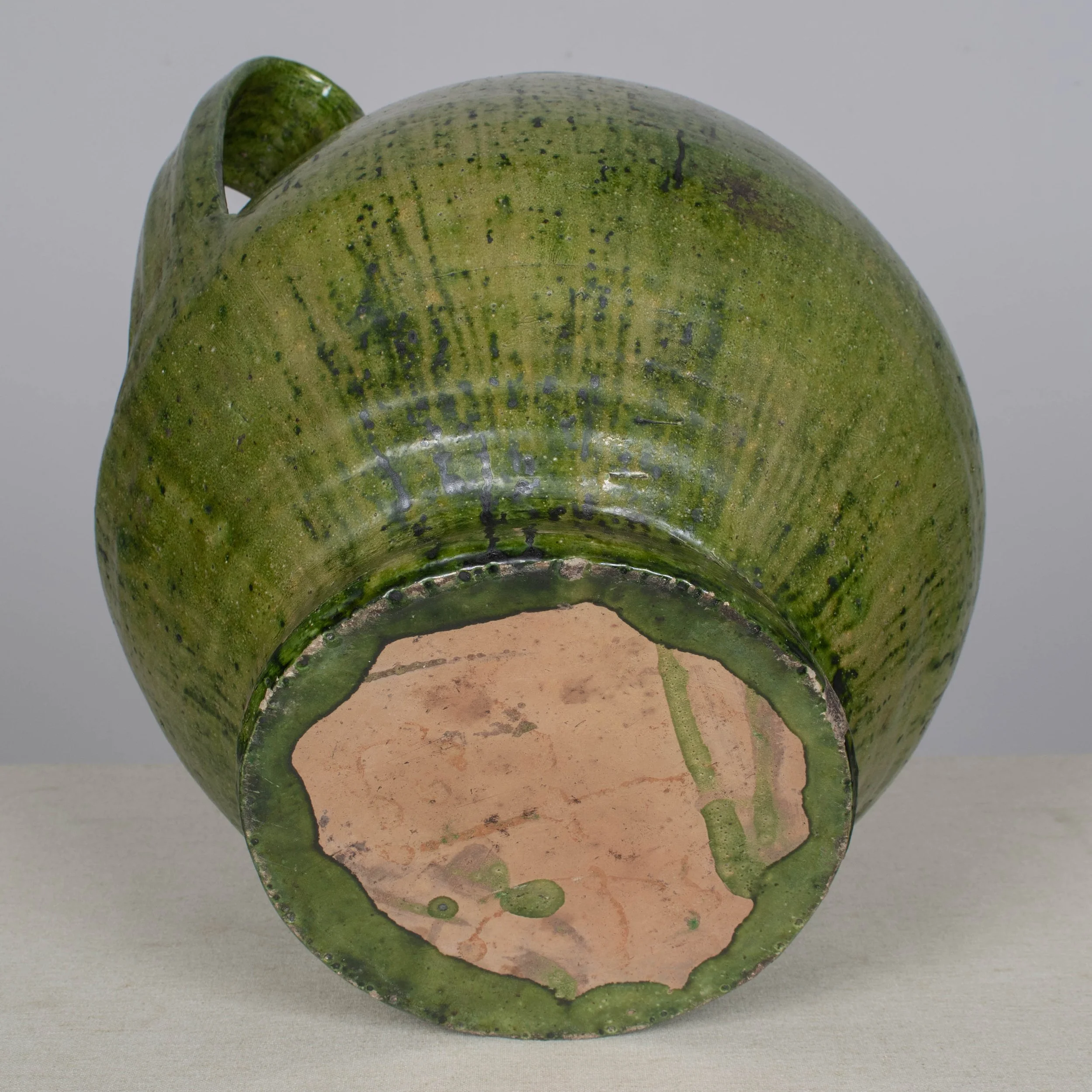 A large green glazed earthenware lidded jar made in Portugal