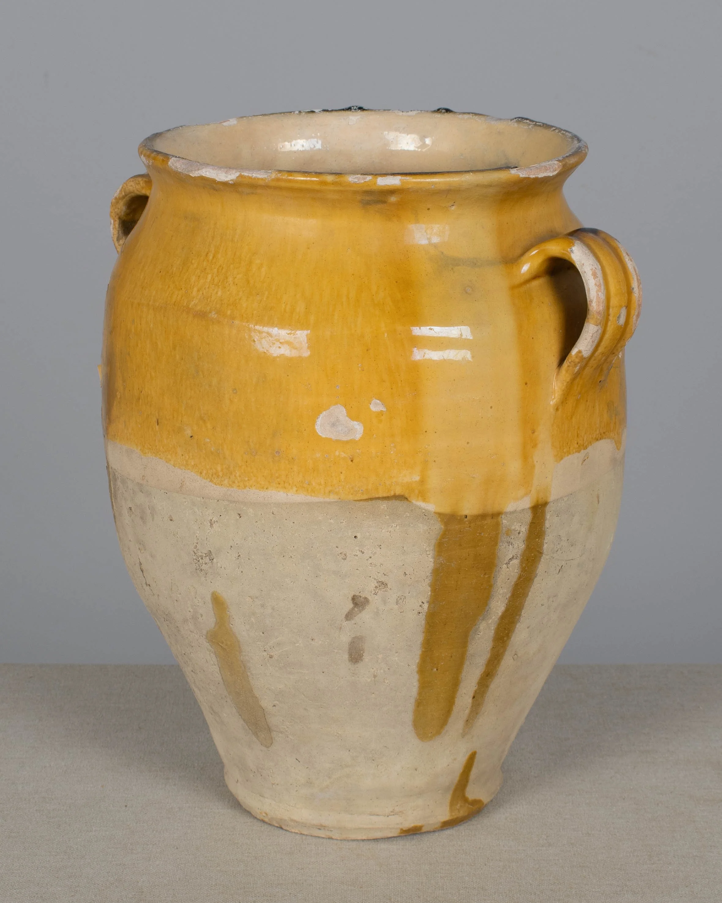 An earthenware confit pot from the Southwest of France with traditional yellow ochre drip glaze.