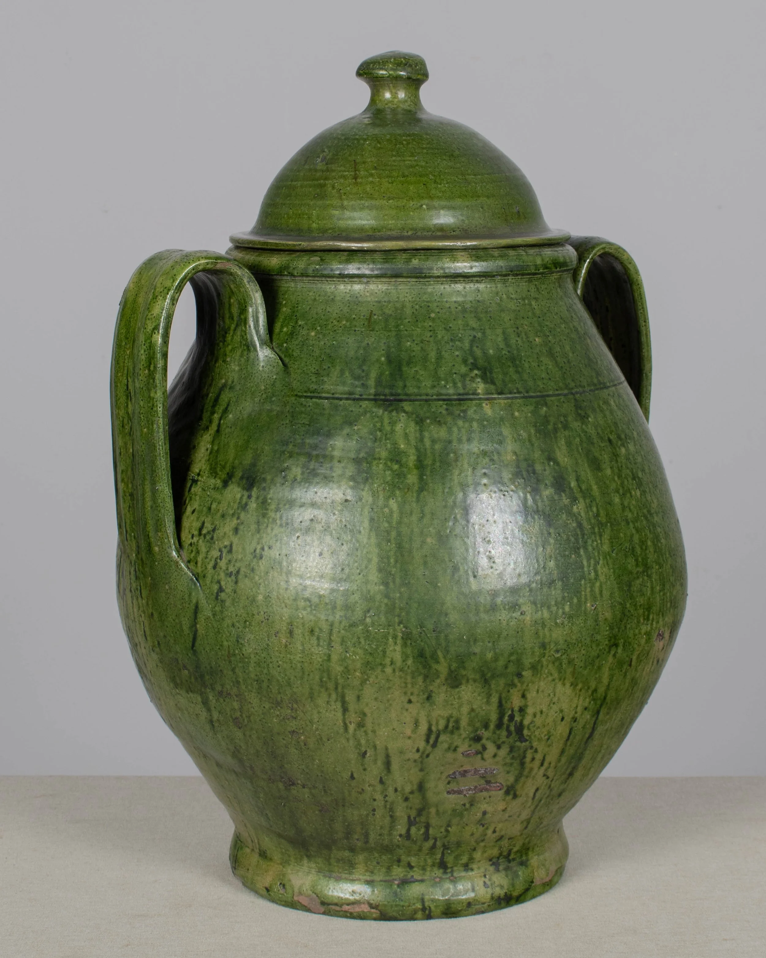 A large green glazed earthenware lidded jar made in Portugal