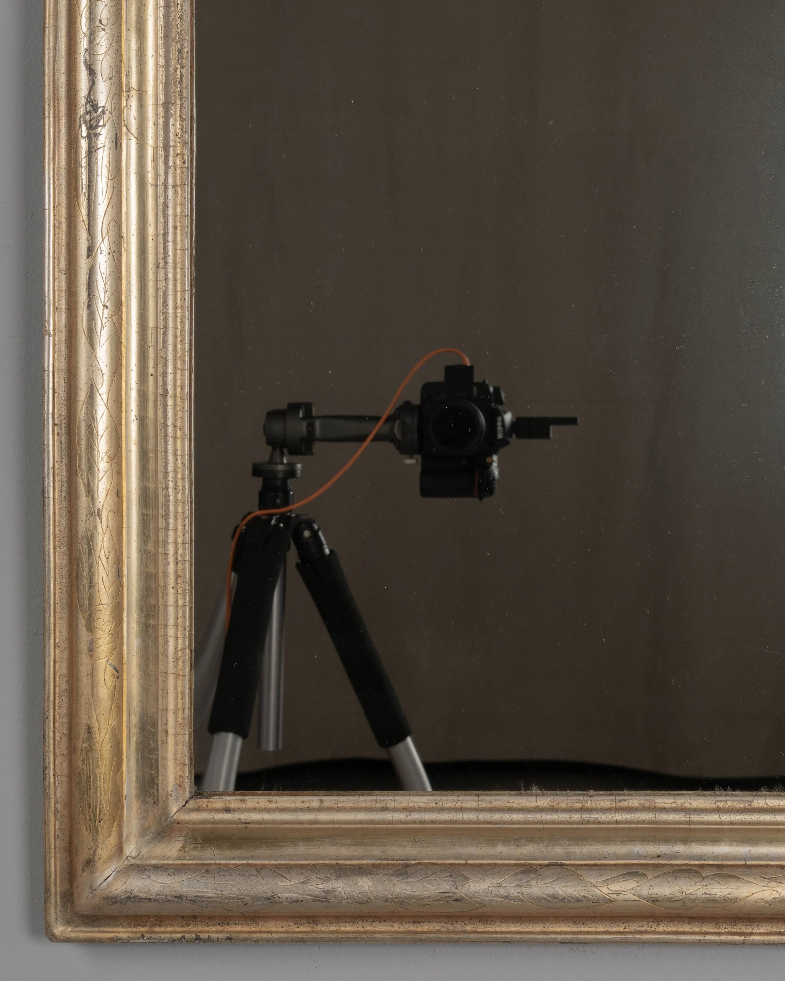 A French Louis Philippe style gilded mirror with curved top corners and incised floral decoration.