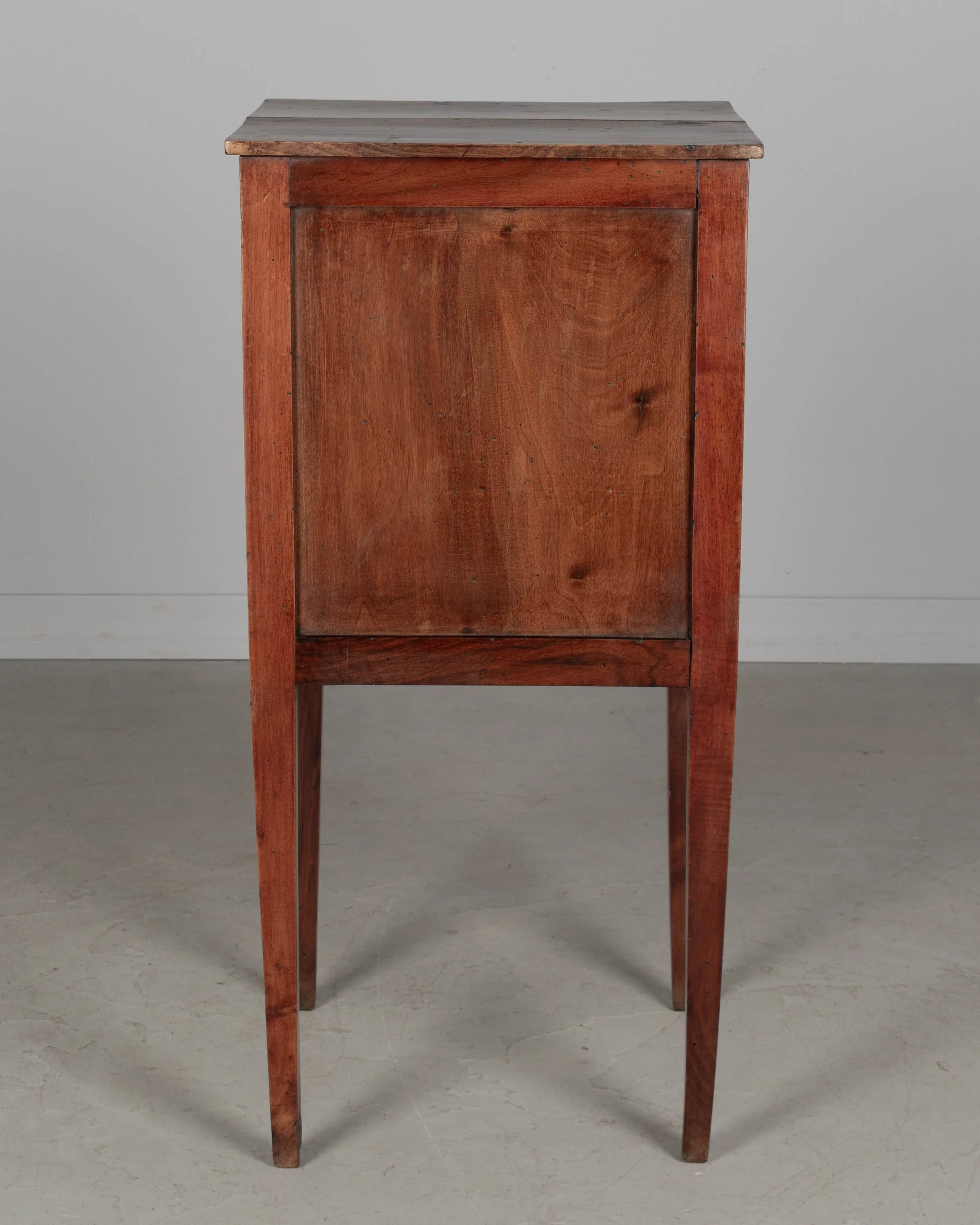 A 19th century French Country walnut side table, or nightstand, with a vertical tambour door above a slim dovetailed drawer