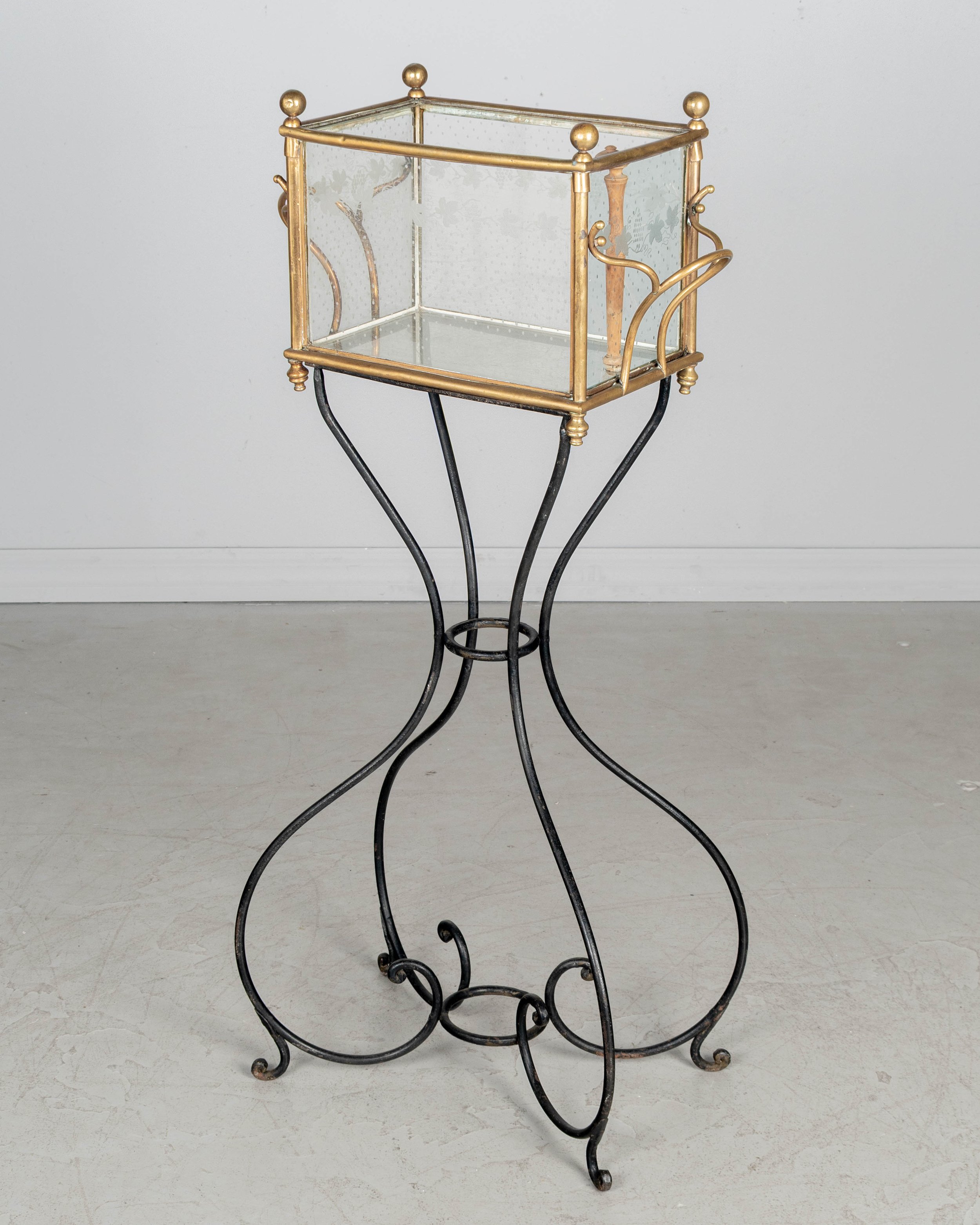 A 19th century French Napoleon III etched glass and brass rafraichissoir, or ice chest, on a black wrought iron stand.
