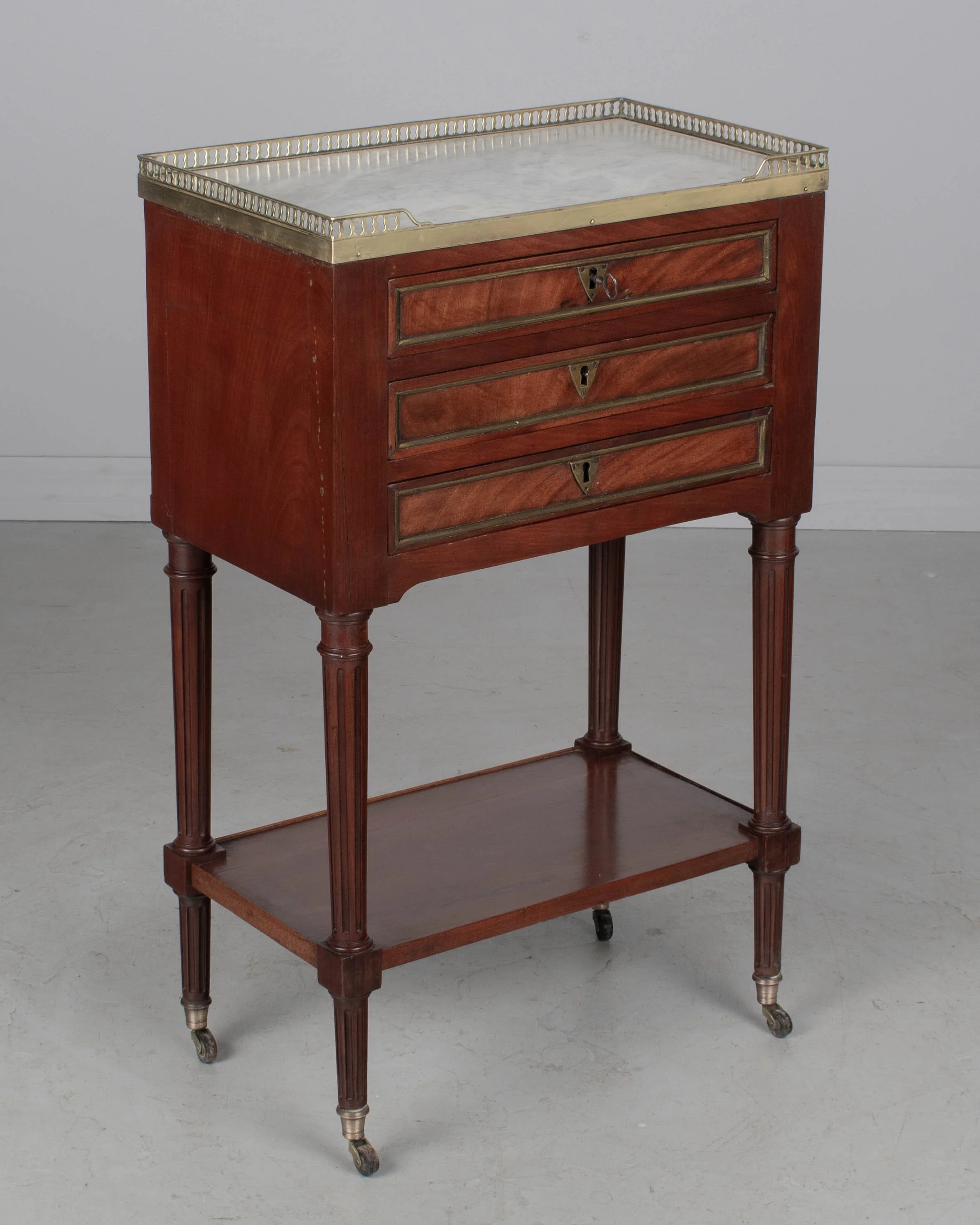 A 19th century French Louis XVI style marble top nightstand, or side table, made of veneers of mahogany with solid oak as a secondary wood