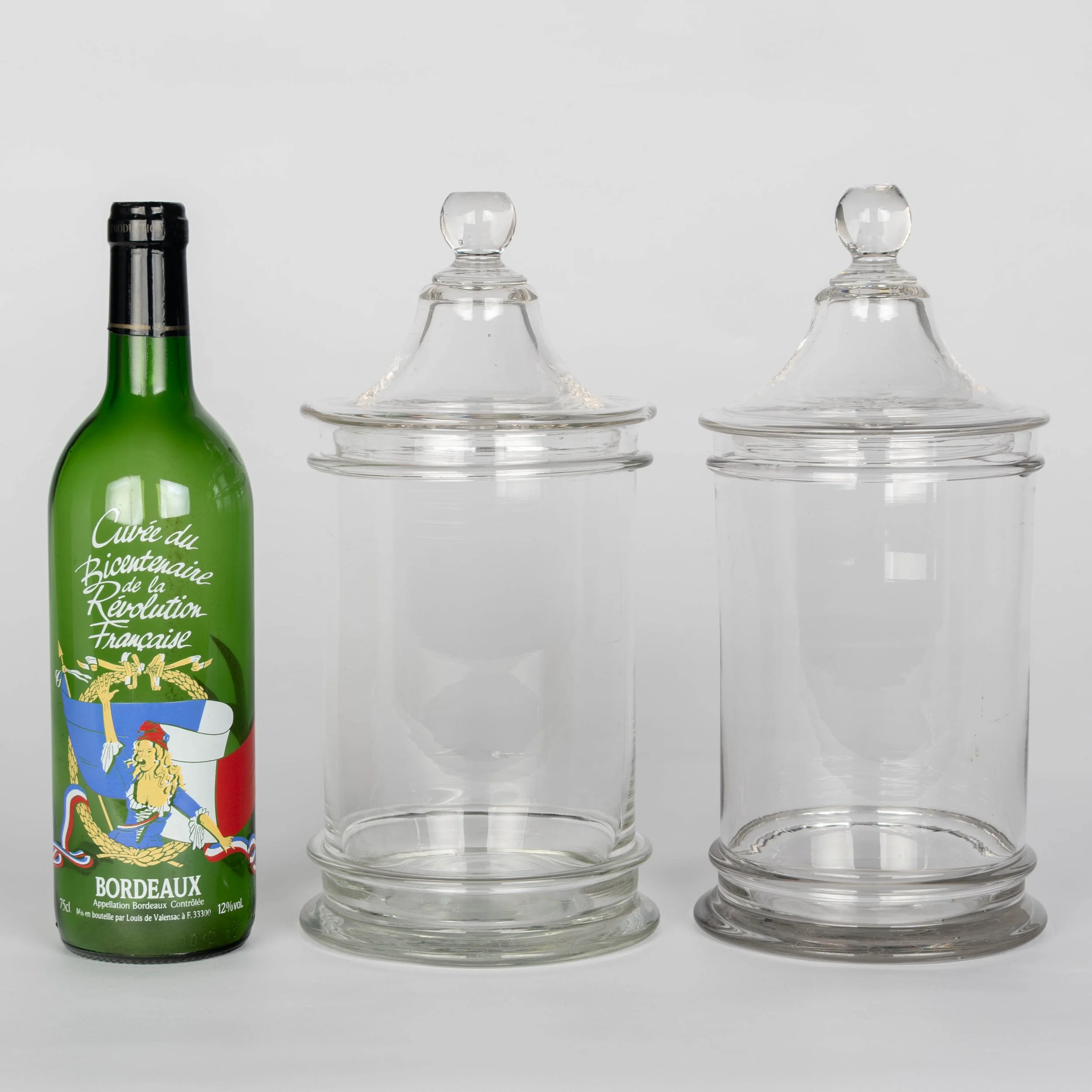 A pair of French hand-blown clear glass lidded apothecary or candy jars