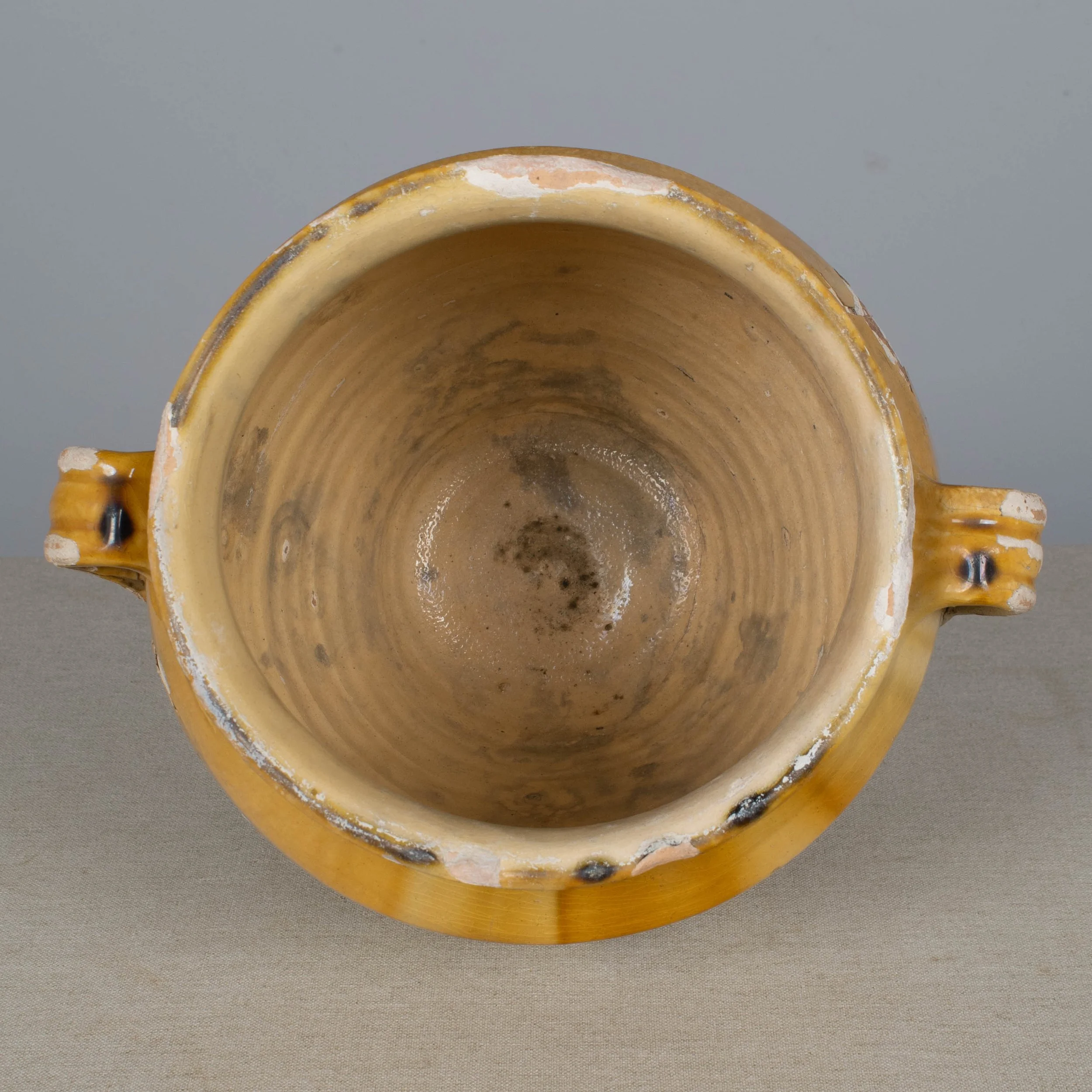 An earthenware confit pot from the Southwest of France with traditional yellow ochre drip glaze.