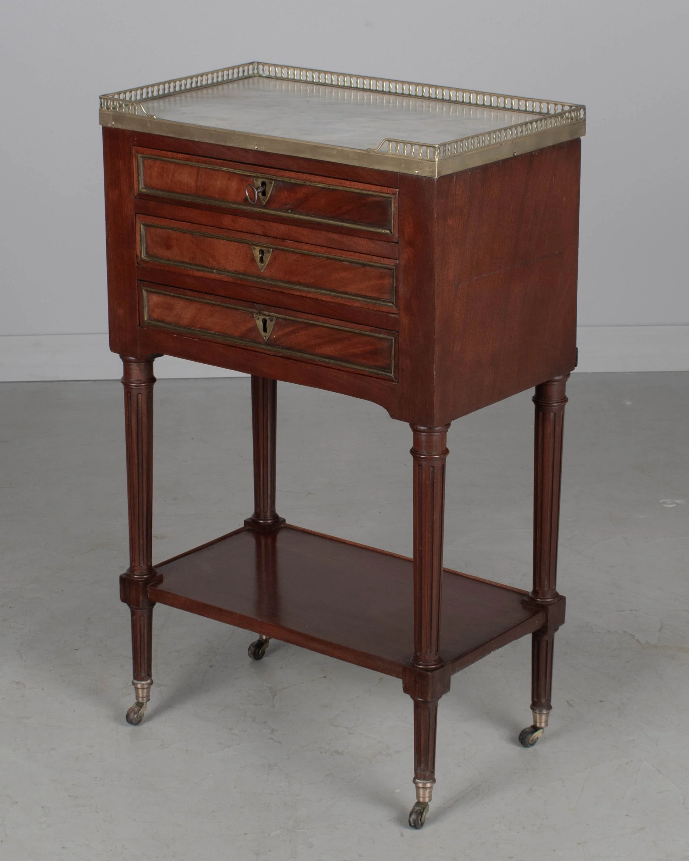 A 19th century French Louis XVI style marble top nightstand, or side table, made of veneers of mahogany with solid oak as a secondary wood