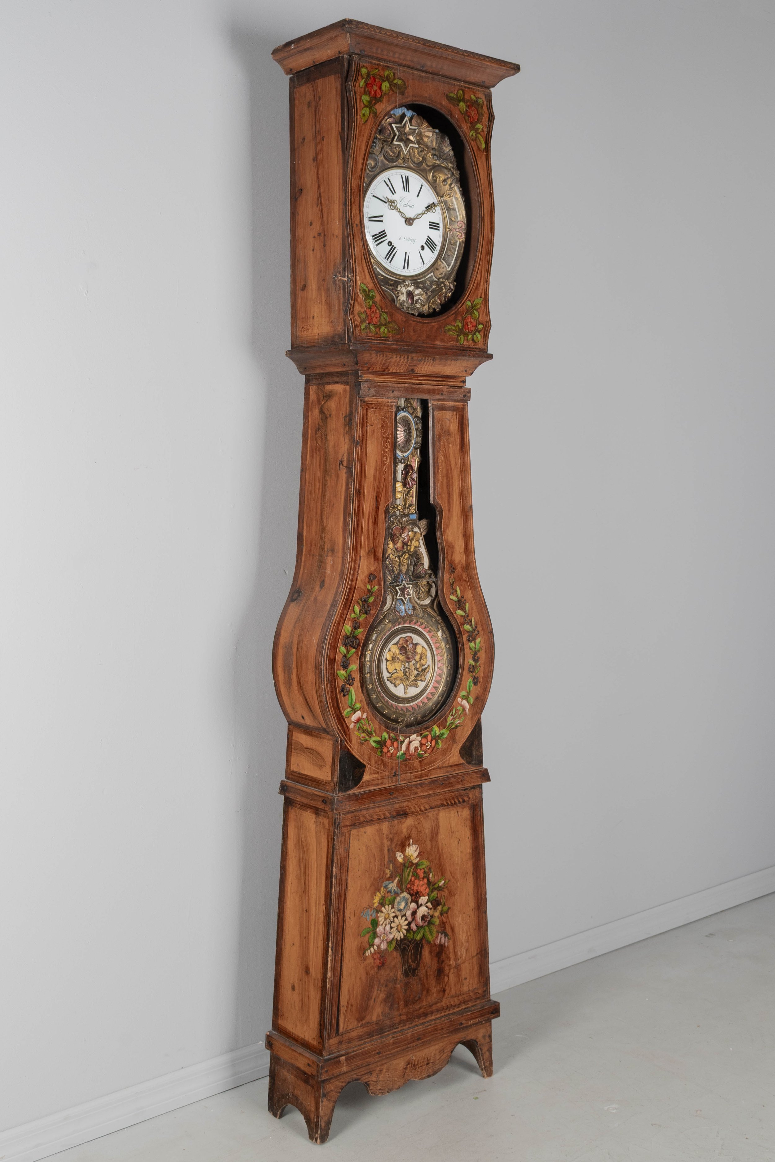 19th century Country French comtoise, or grandfather clock, with polychrome painted pine case and embossed brass pendulum.