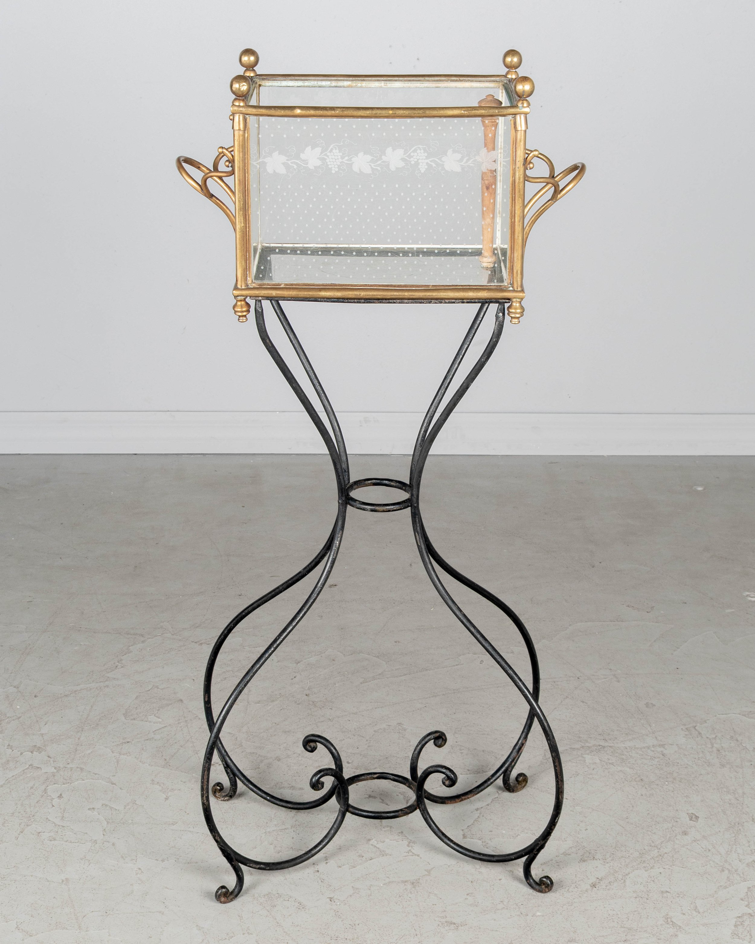 A 19th century French Napoleon III etched glass and brass rafraichissoir, or ice chest, on a black wrought iron stand.