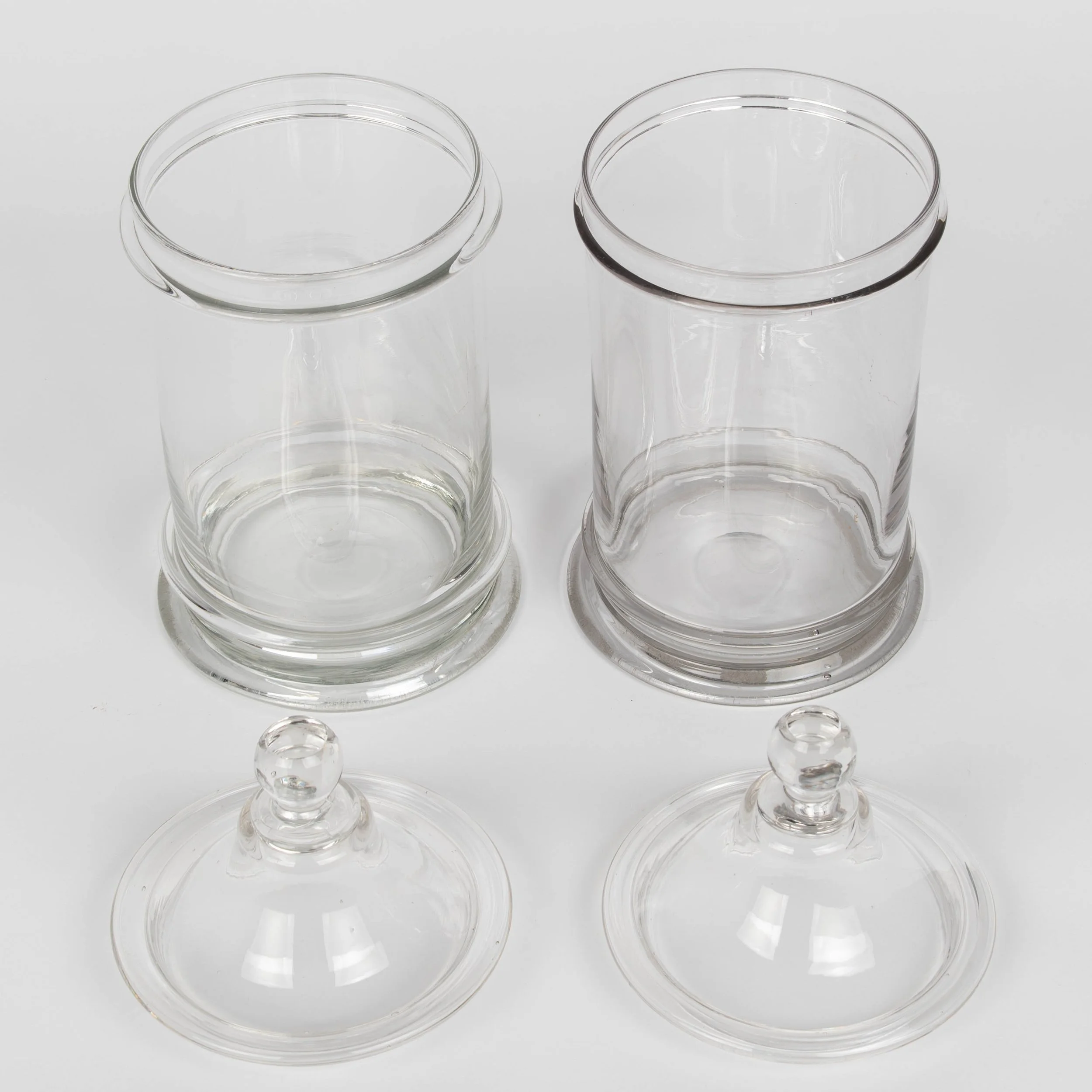A pair of French hand-blown clear glass lidded apothecary or candy jars