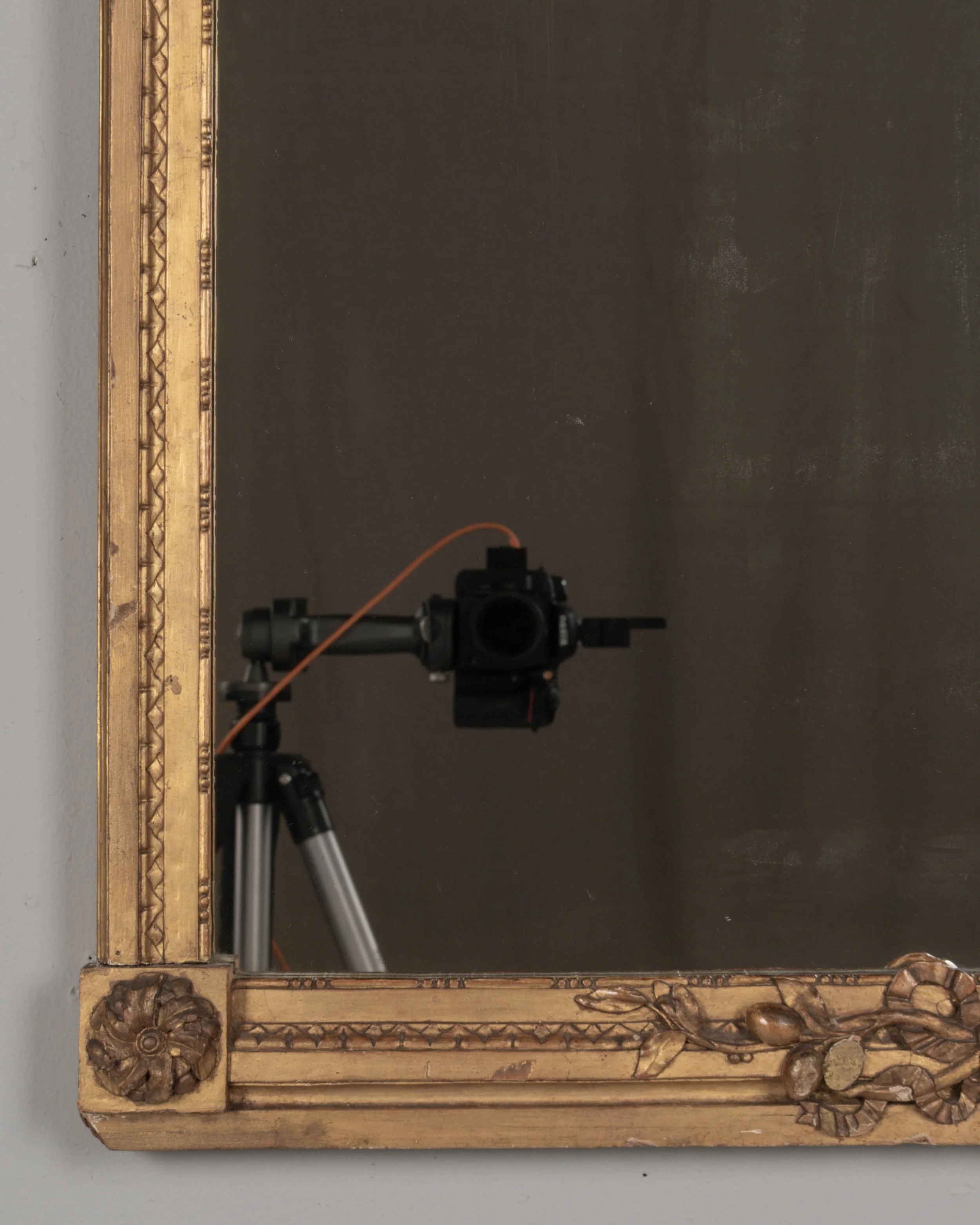 A Louis XVI style French giltwood mirror. Hand carved crest with large urn, torch, ribbons, and garlands.