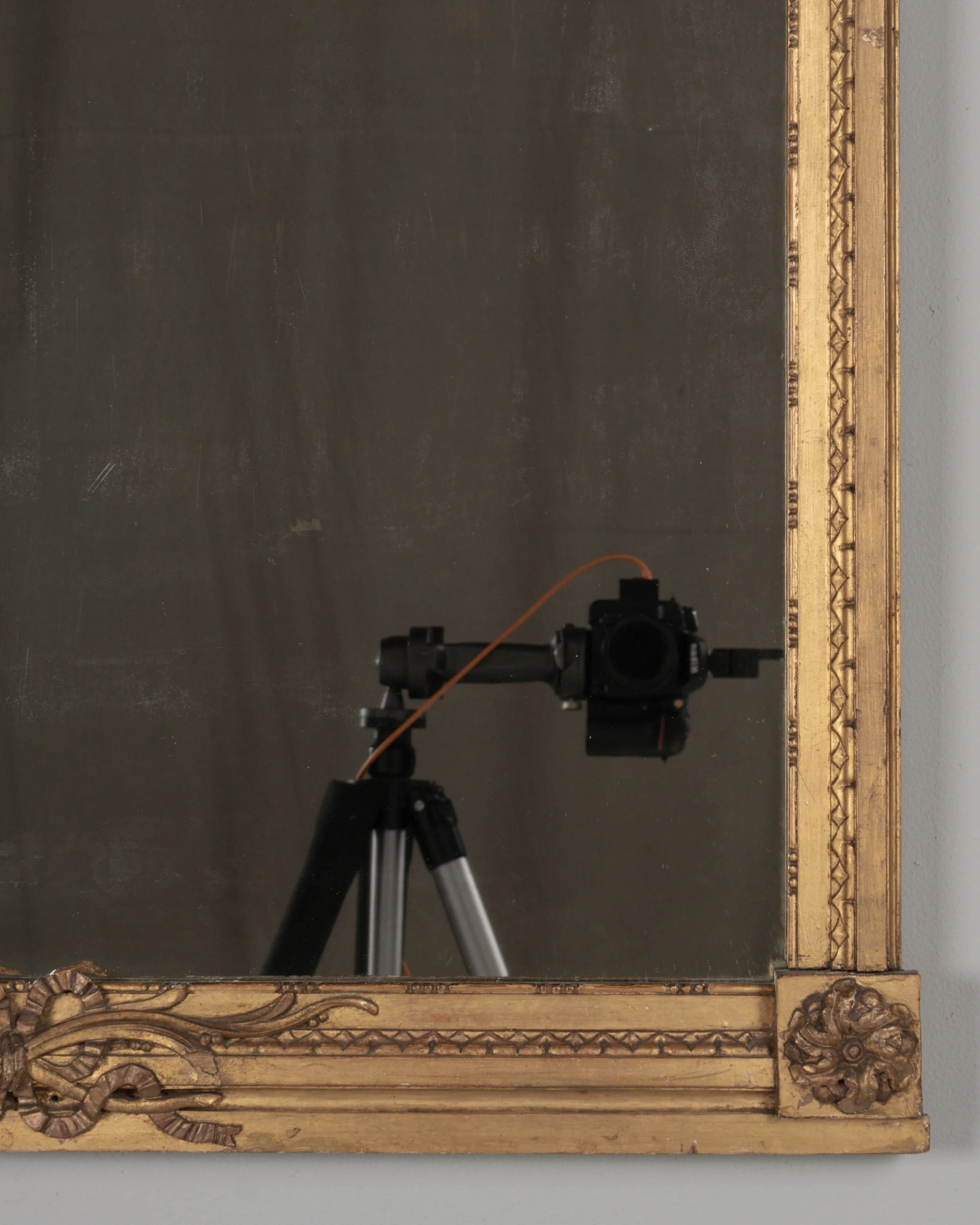 A Louis XVI style French giltwood mirror. Hand carved crest with large urn, torch, ribbons, and garlands.