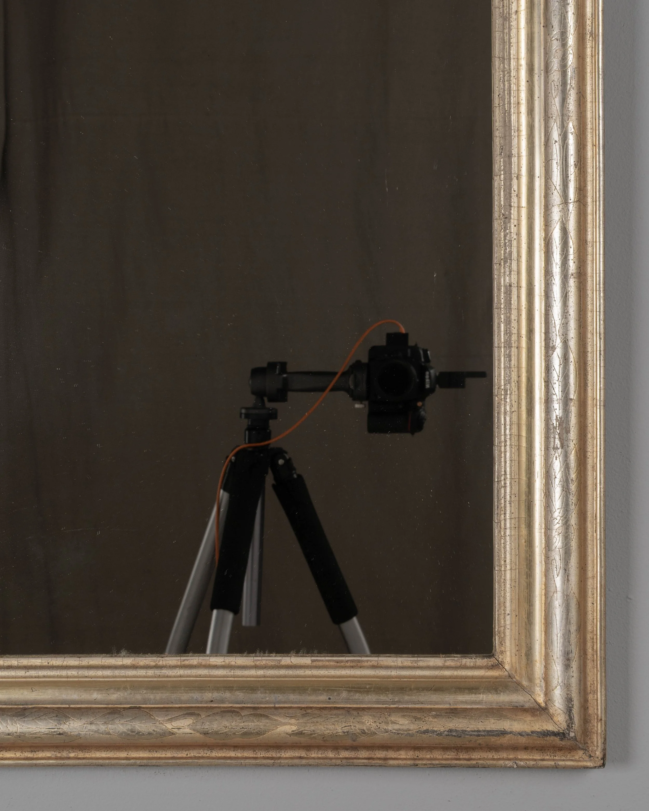 A French Louis Philippe style gilded mirror with curved top corners and incised floral decoration.