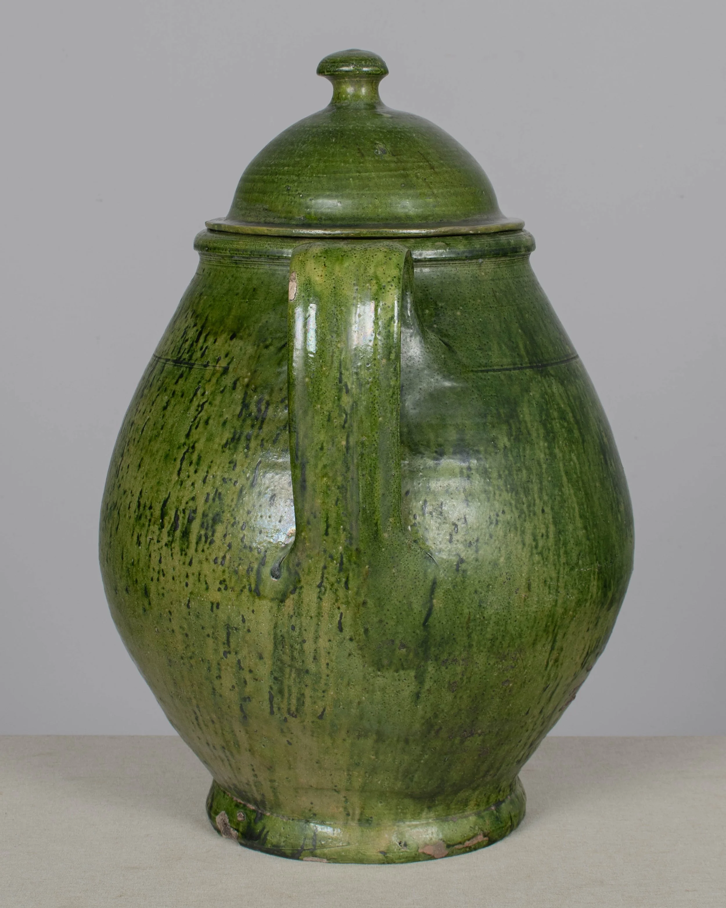 A large green glazed earthenware lidded jar made in Portugal