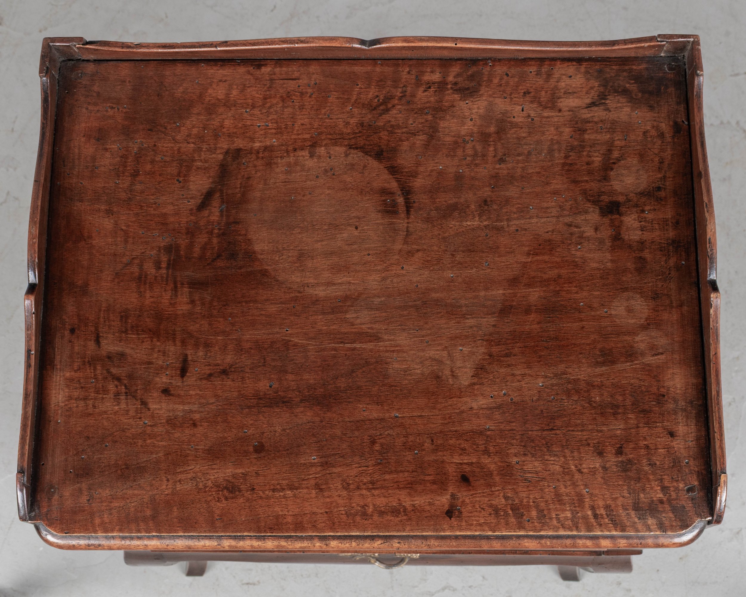 An early 20th century Louis XV Country French side table or nightstand made of solid walnut with an open niche and pierced heart shaped cut-outs on the sides.