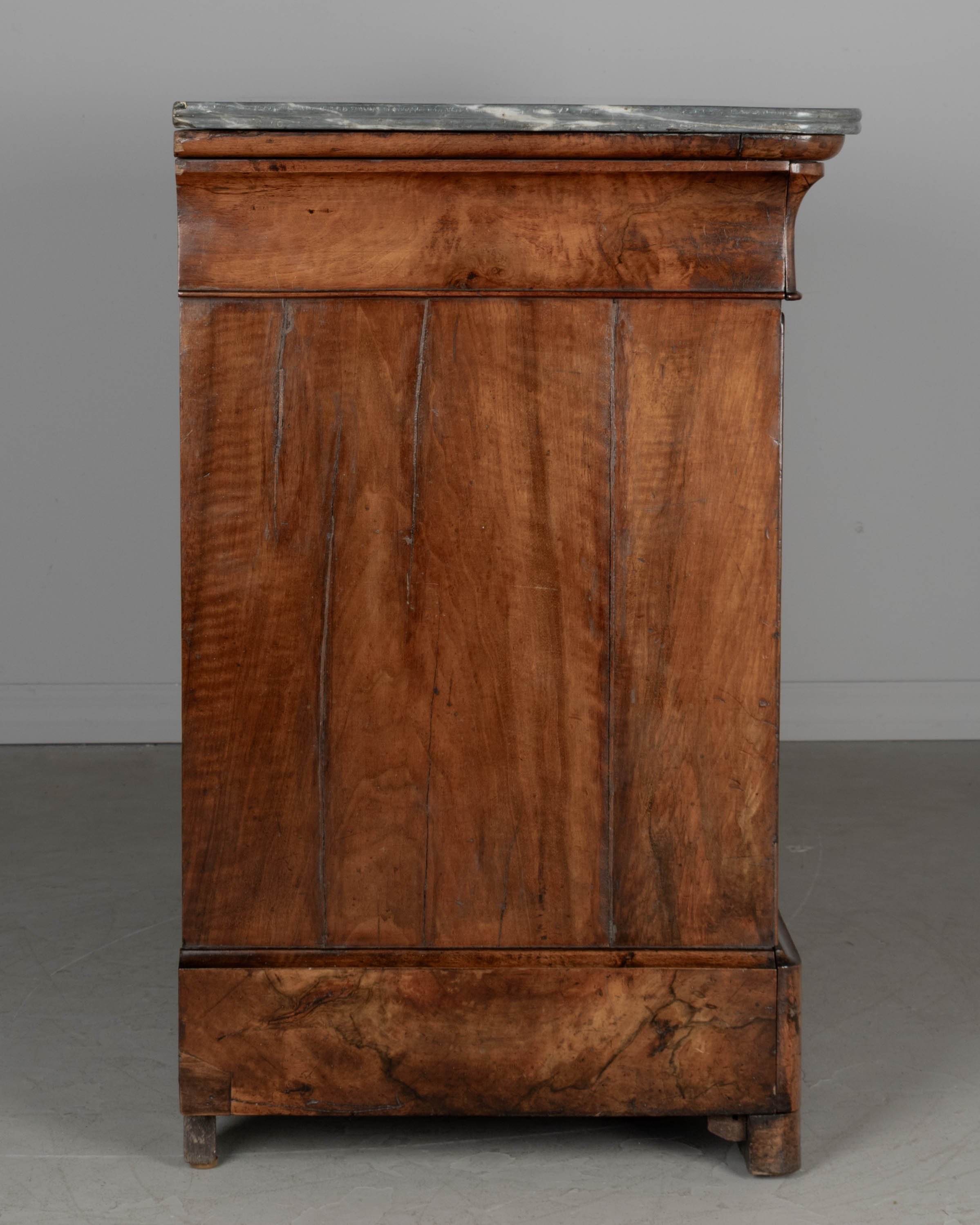 An early 19th century French Louis Philippe marble top walnut commode, or chest of drawers.
