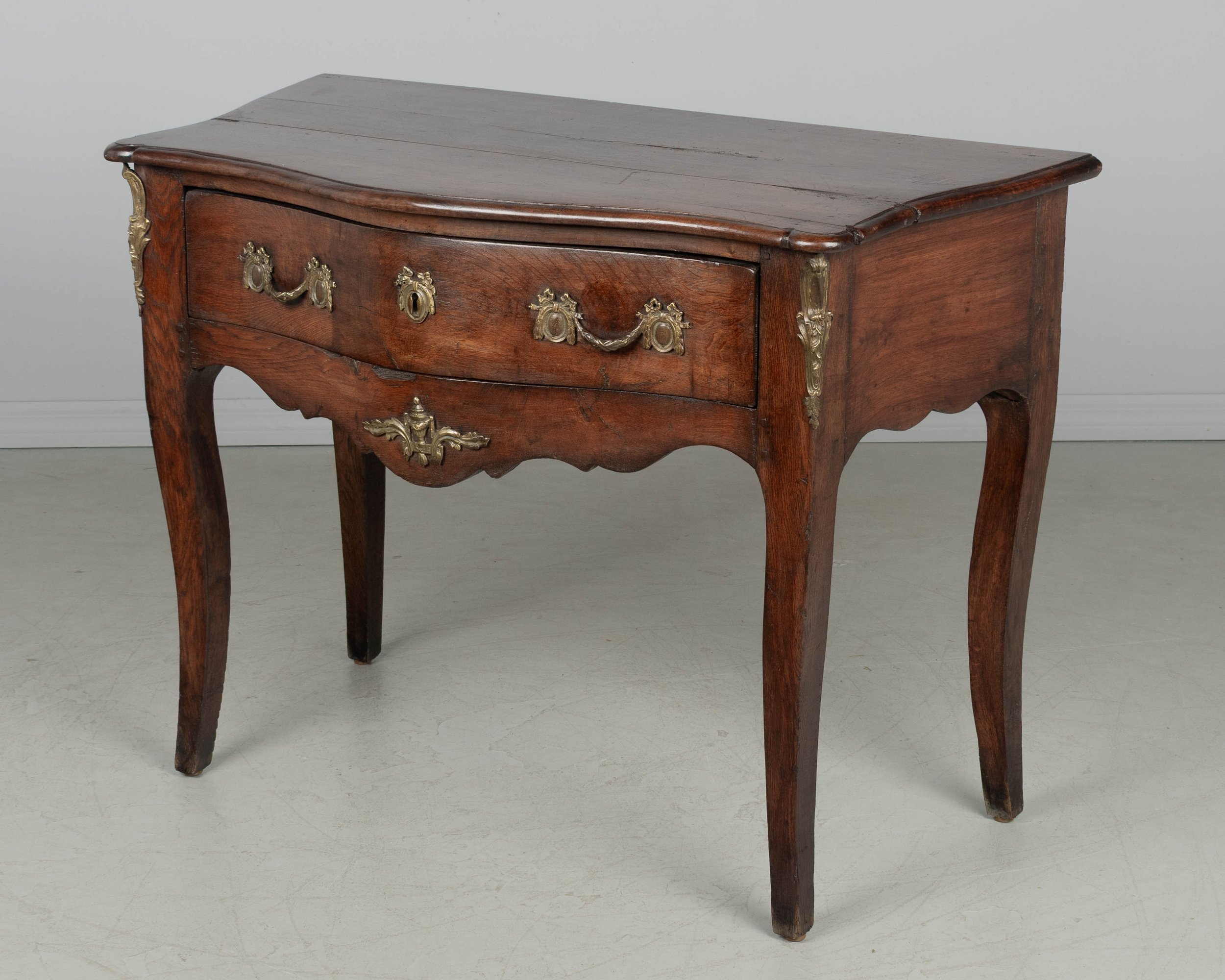 An 18th century Louis XV style French Provençal console table with serpentine front,