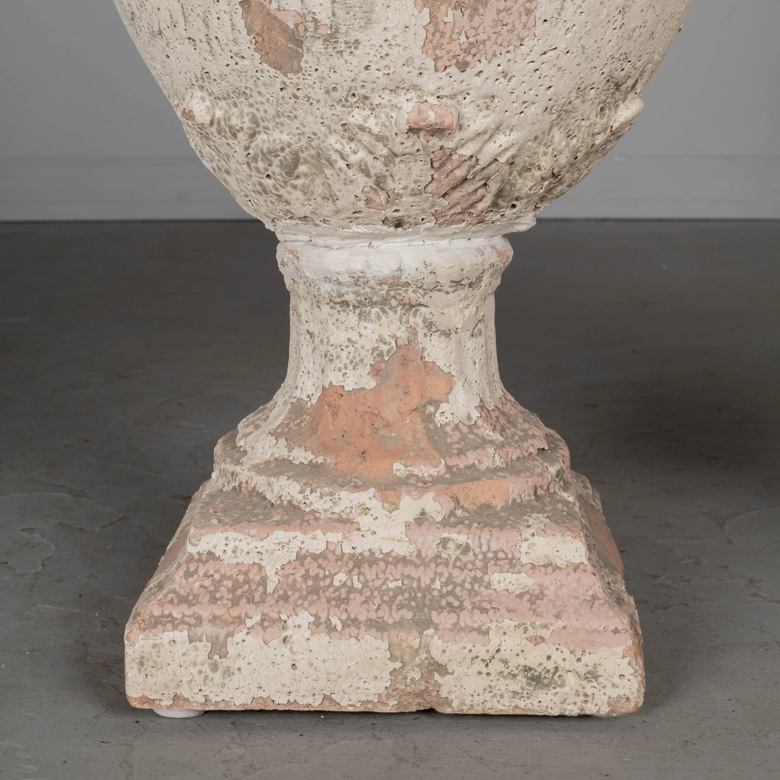 A pair of French terracotta garden urns with lids. Classical vase form on pedestal base, decorated in acanthus leaf motif with large acorn finials on lids.