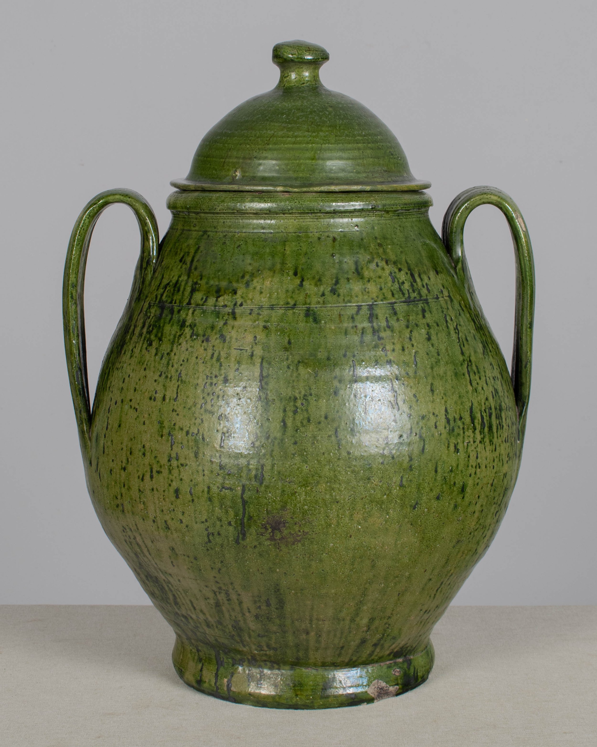 A large green glazed earthenware lidded jar made in Portugal