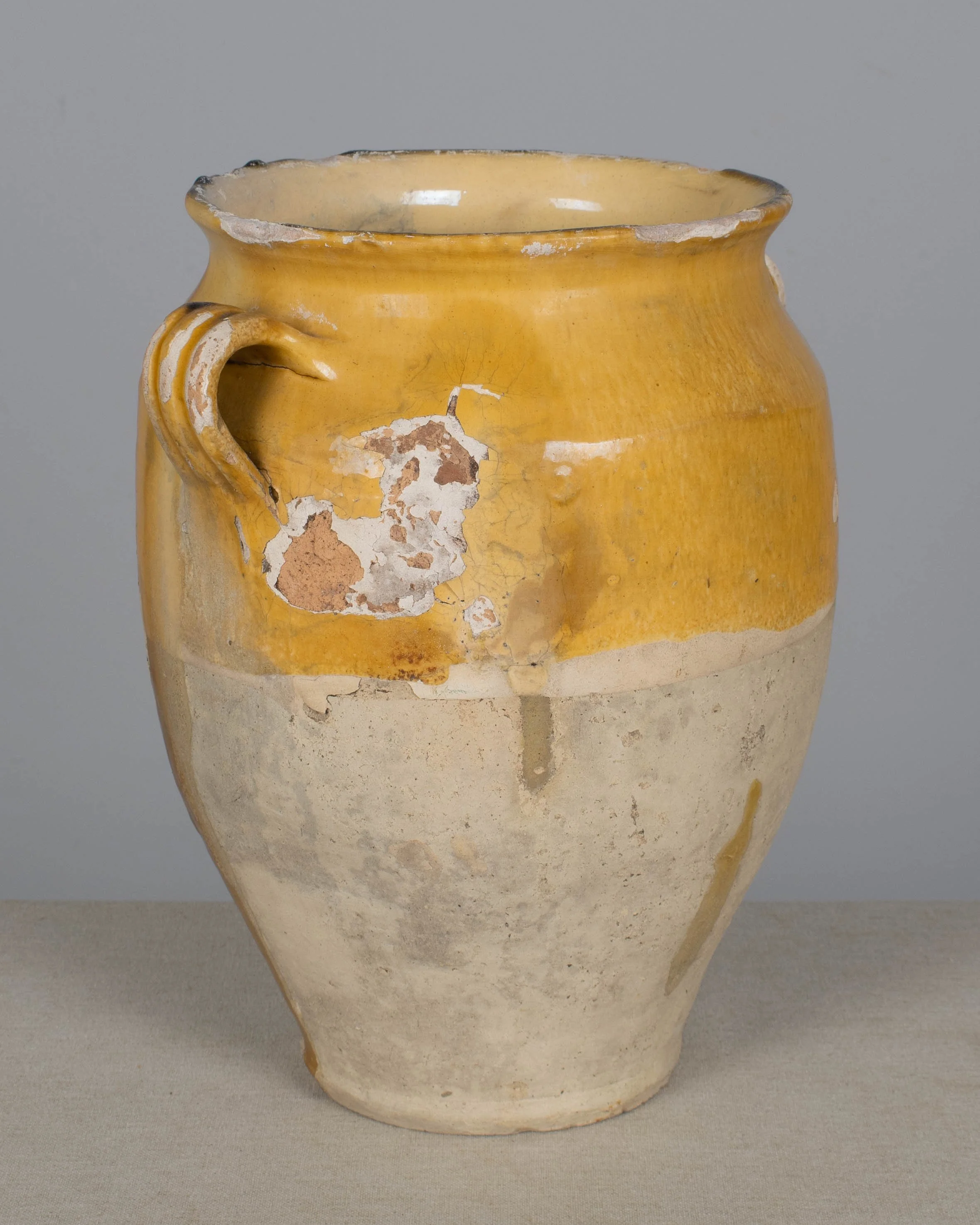 An earthenware confit pot from the Southwest of France with traditional yellow ochre drip glaze.