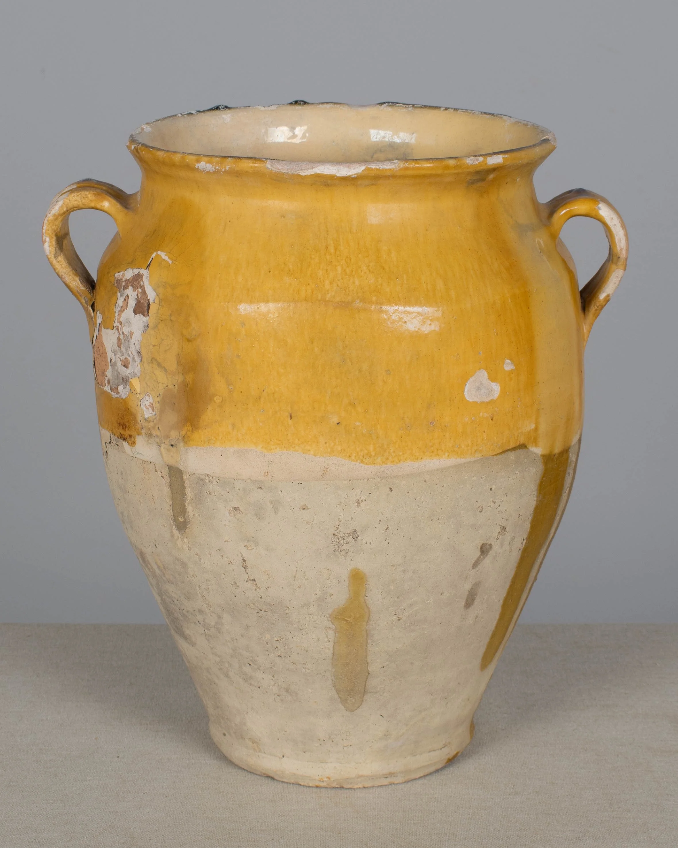 An earthenware confit pot from the Southwest of France with traditional yellow ochre drip glaze.