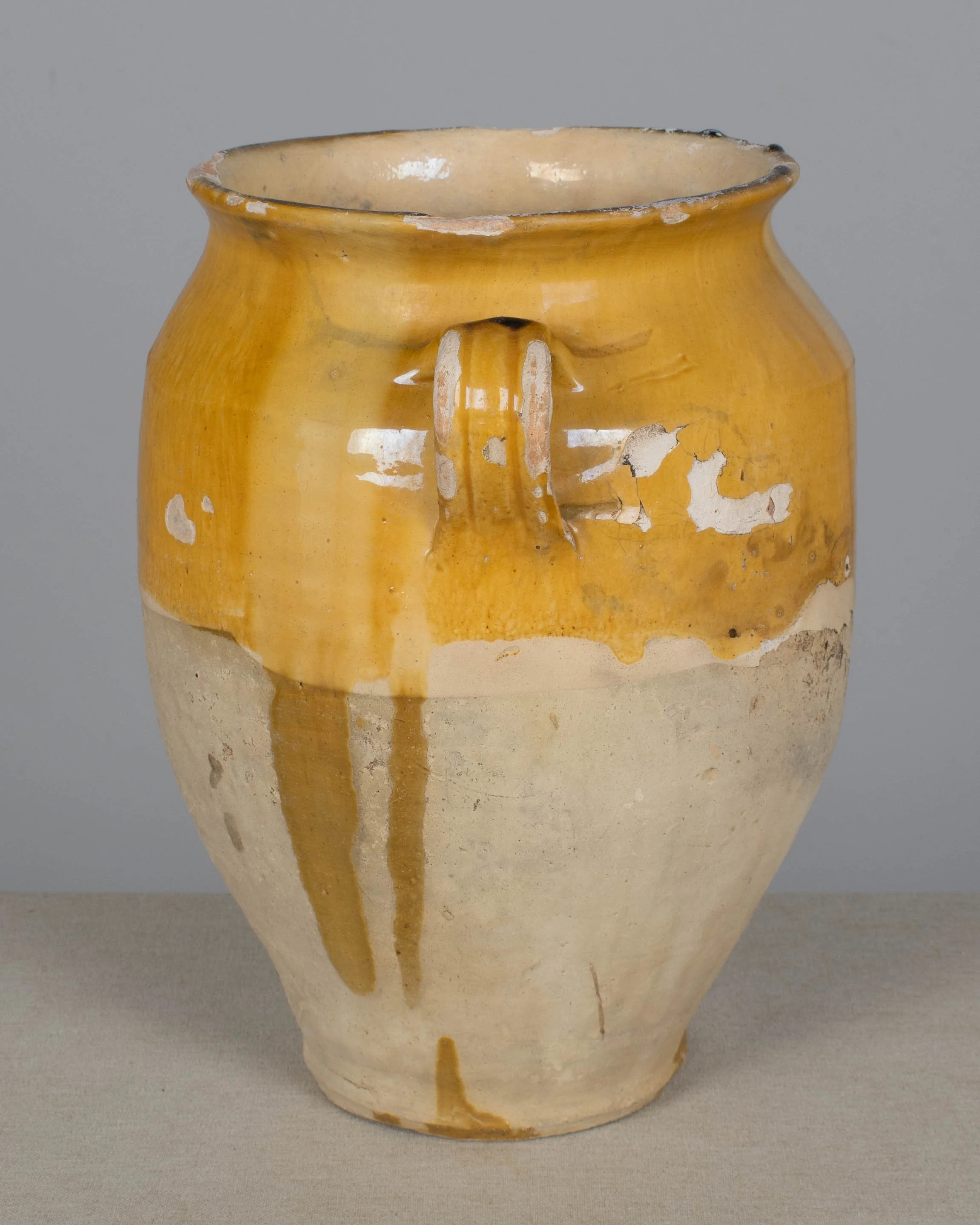 An earthenware confit pot from the Southwest of France with traditional yellow ochre drip glaze.