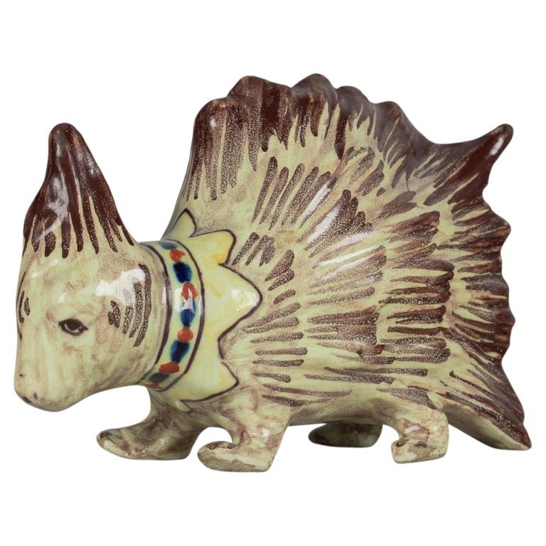 A late 19th century French Blois faience whimsical porcupine figurine. Hand-painted with greenish yellow body and brown needles, and decorated with a blue and red collar.