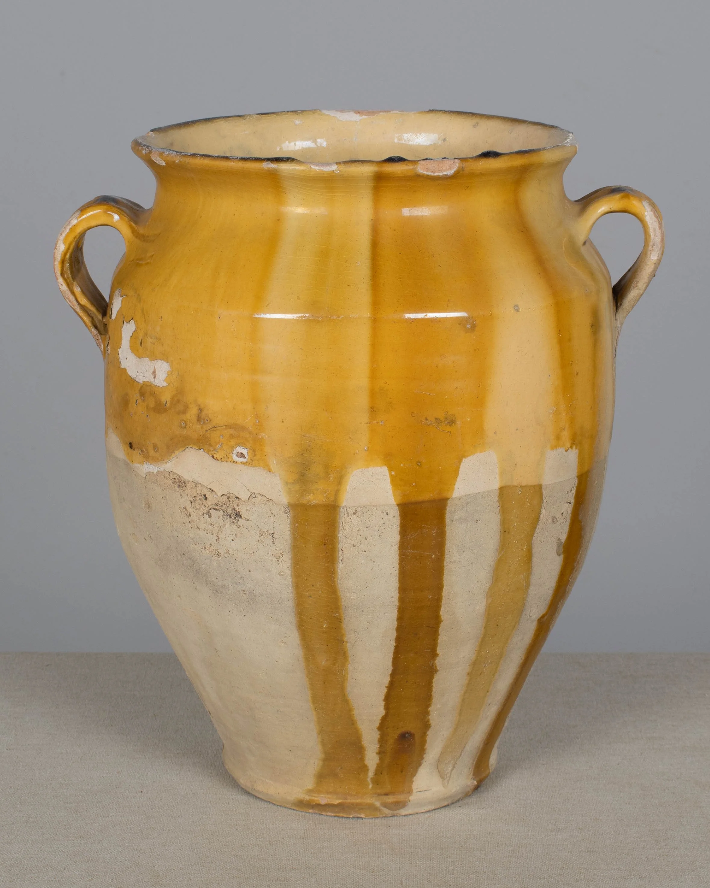 An earthenware confit pot from the Southwest of France with traditional yellow ochre drip glaze.