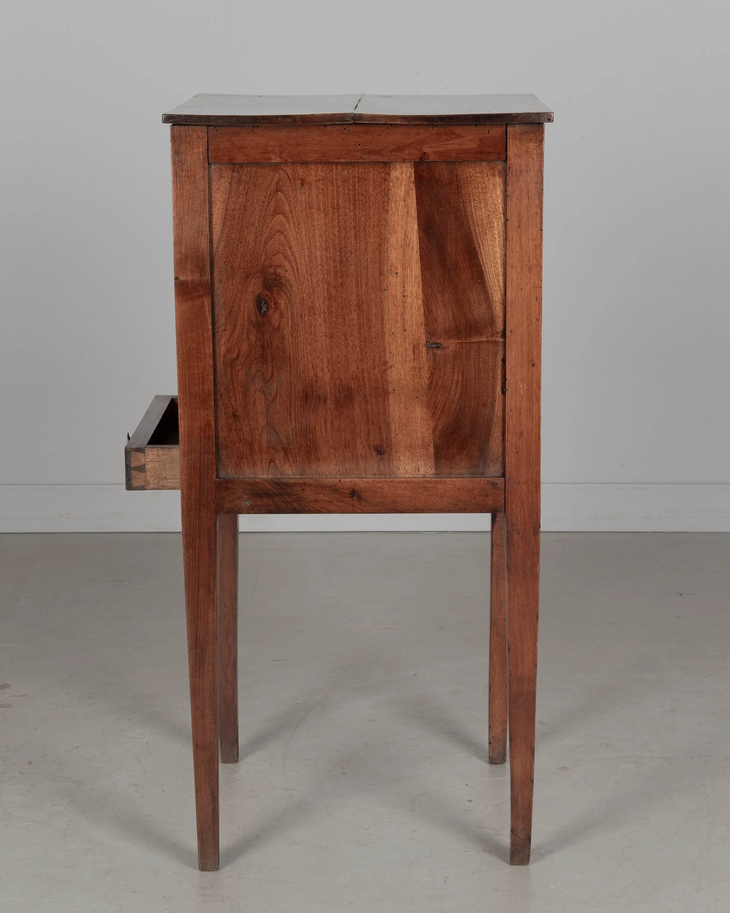 A 19th century French Country walnut side table, or nightstand, with a vertical tambour door above a slim dovetailed drawer