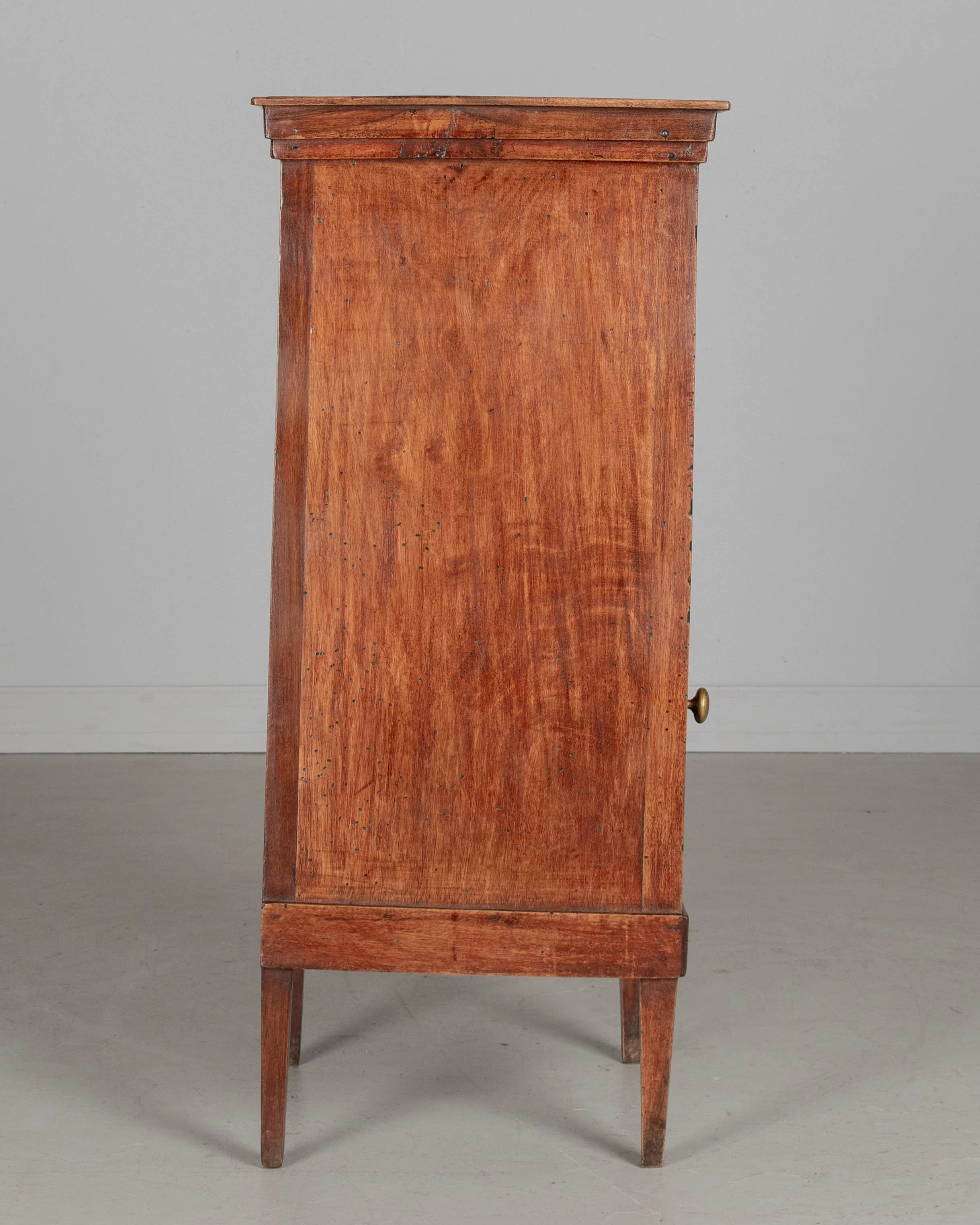 A 19th century French Country walnut side table, or nightstand, with a vertical tambour door above a cabinet door