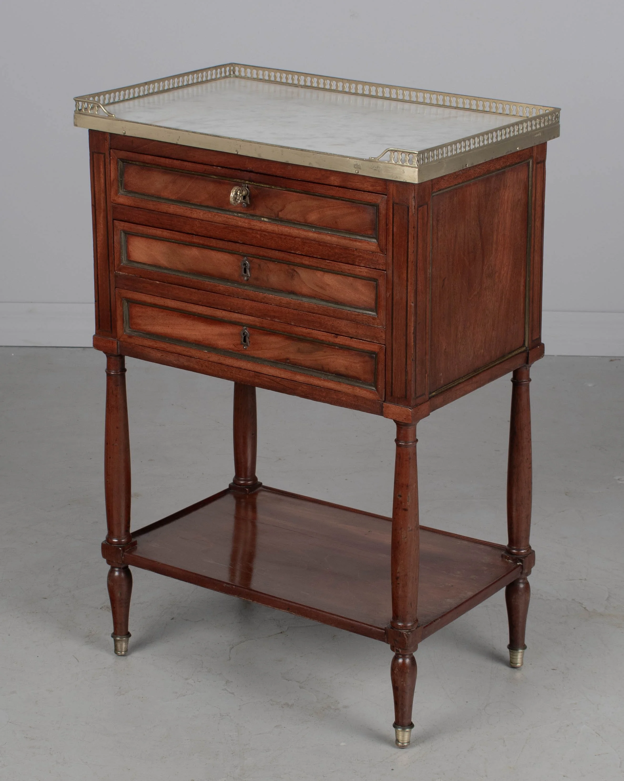 A 19th century French Louis XVI style marble top nightstand, or side table, made of veneers of mahogany with solid oak as a secondary wood