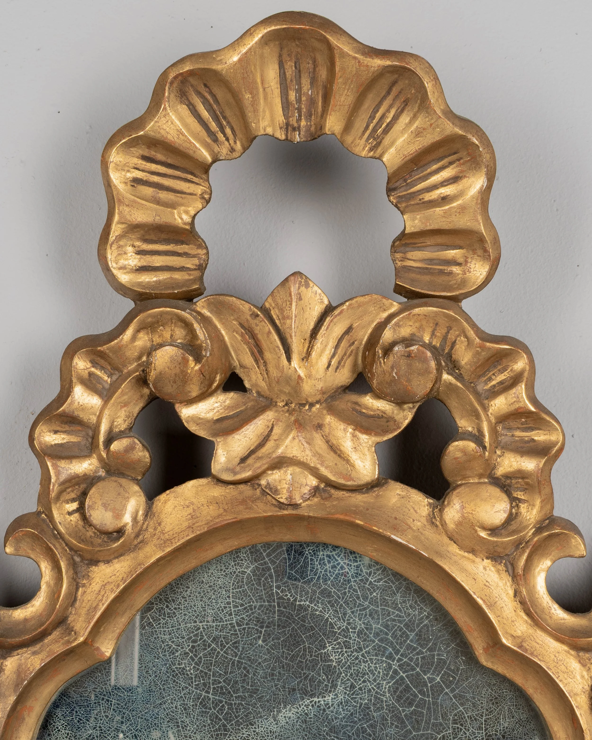 French Baroque style giltwood mirror with cartouche shape framed by undulating borders.