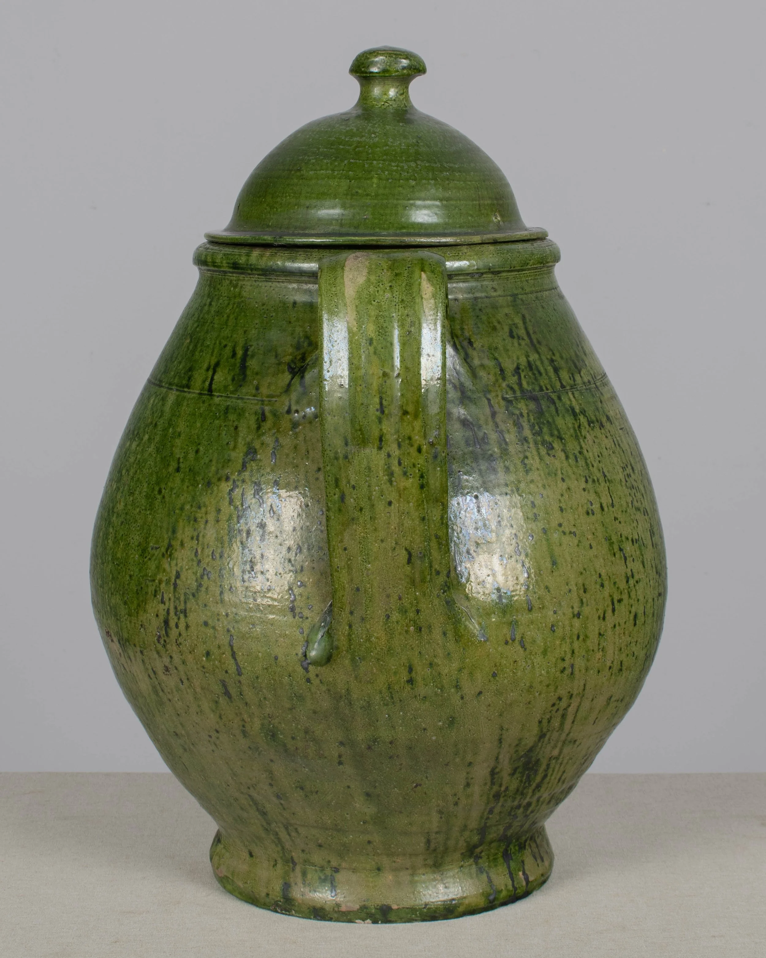 A large green glazed earthenware lidded jar made in Portugal