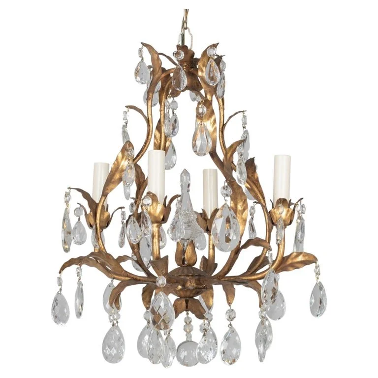 An Italian Hollywood Regency style four-light gilt metal chandelier with tôle leaves and crystal prisms.