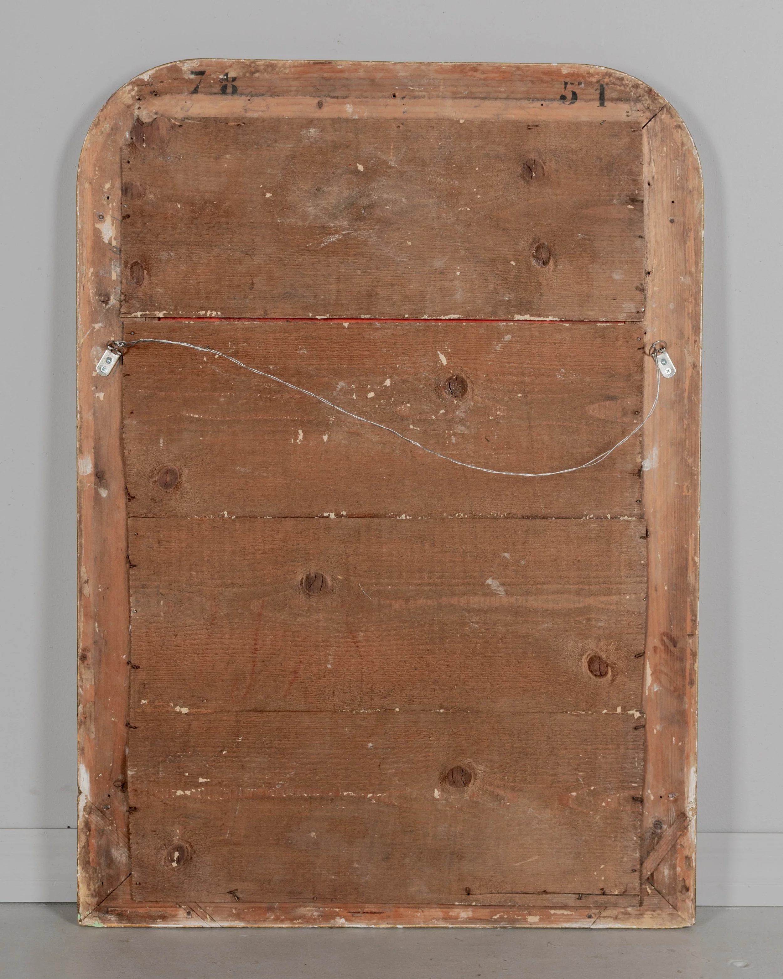 An early 20th century French Louis Philippe style gilded mirror with curved top corners, incised floral decoration and inner bead border.